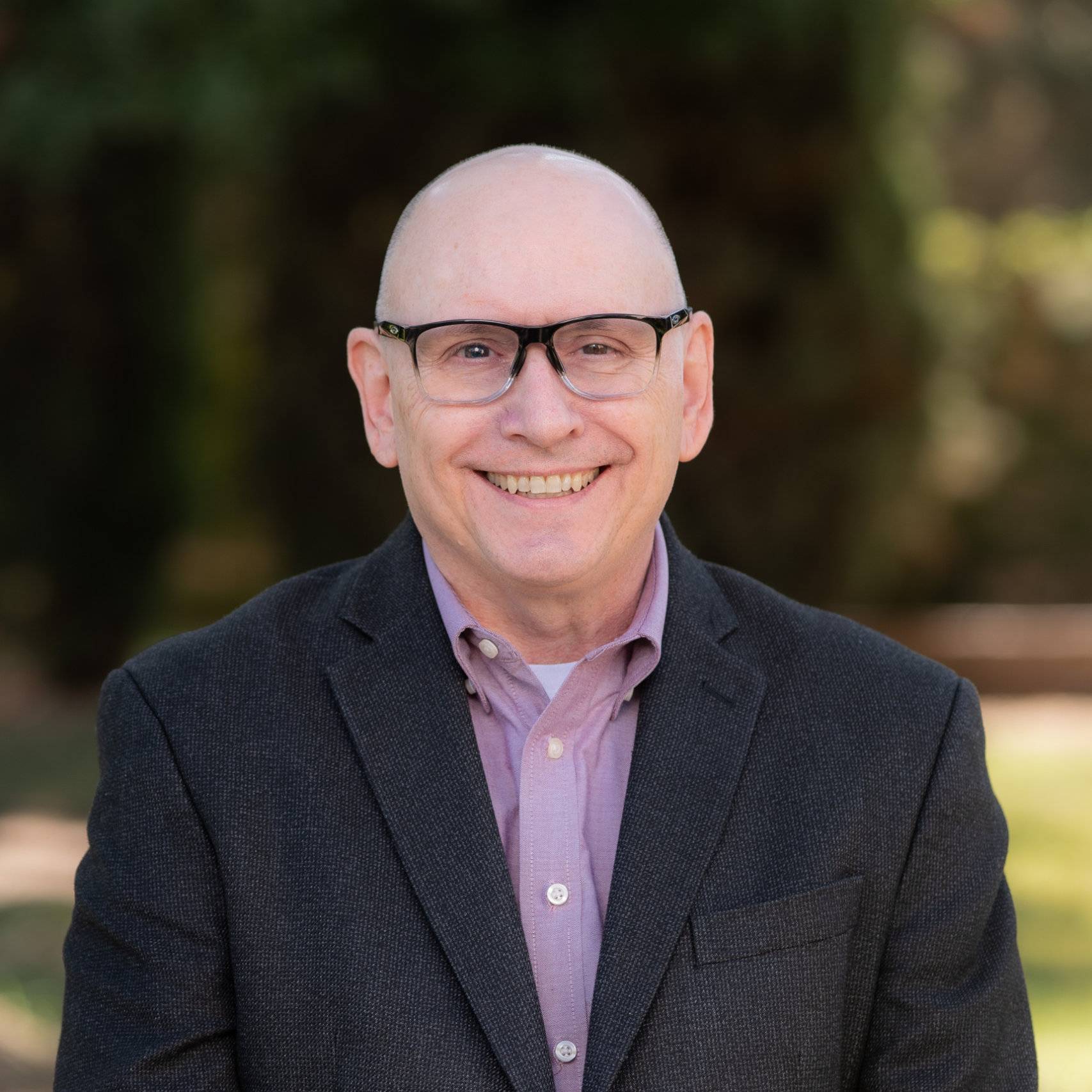 a person wearing glasses and a suit