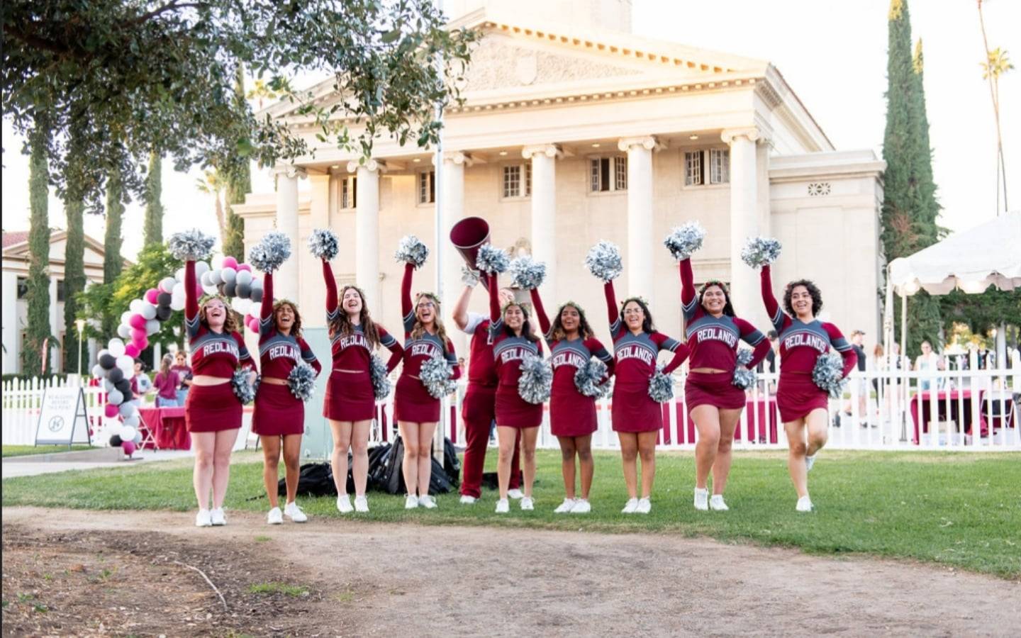a group of cheerleaders in front of a building