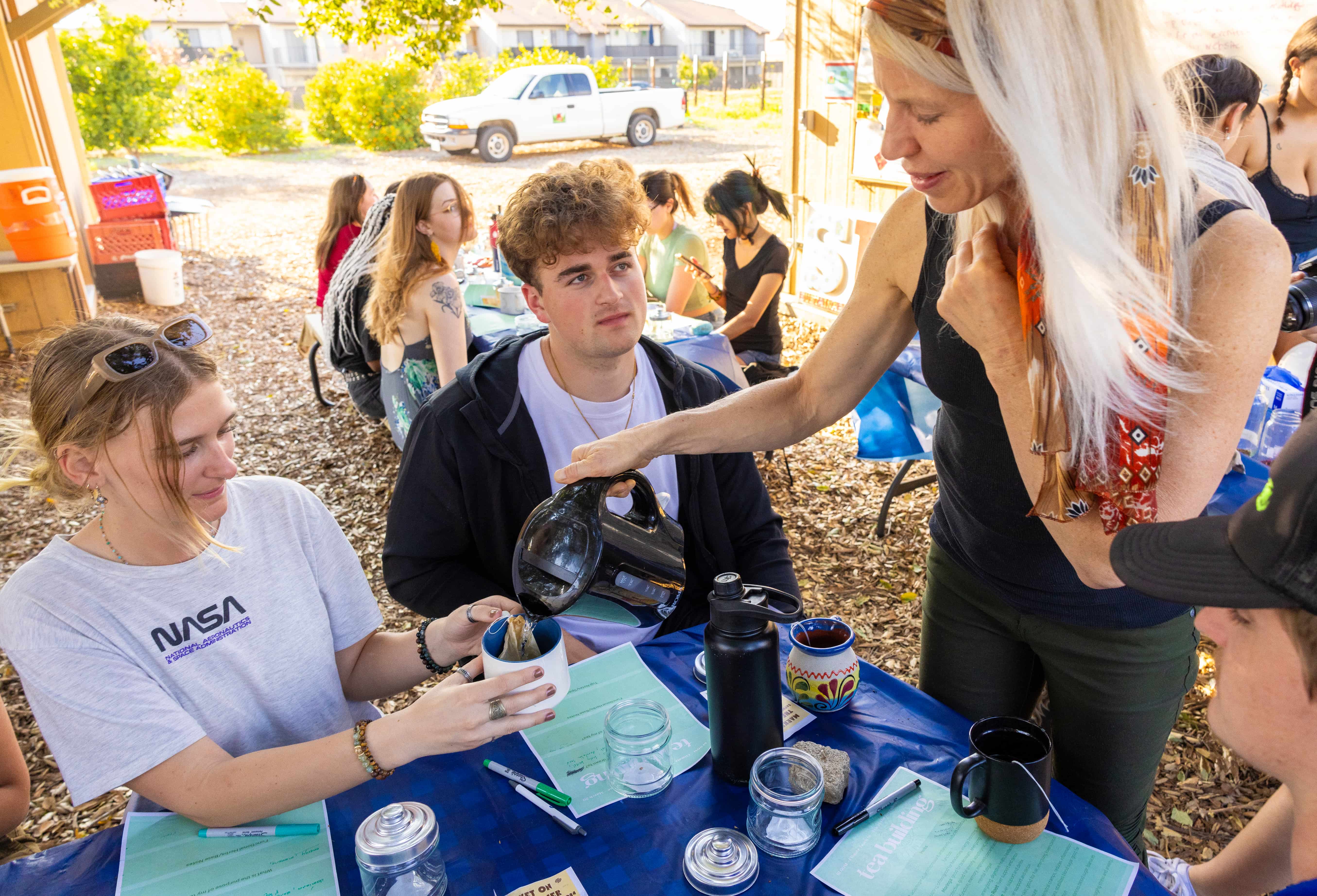 a person pouring tea into a cup