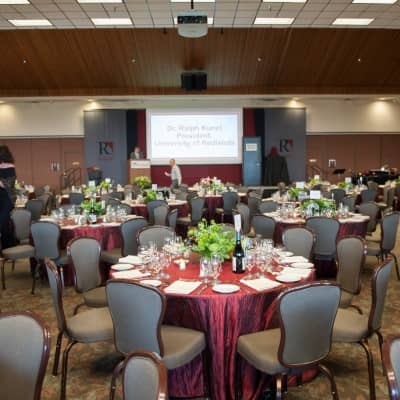 a large round banquet table with tables and chairs