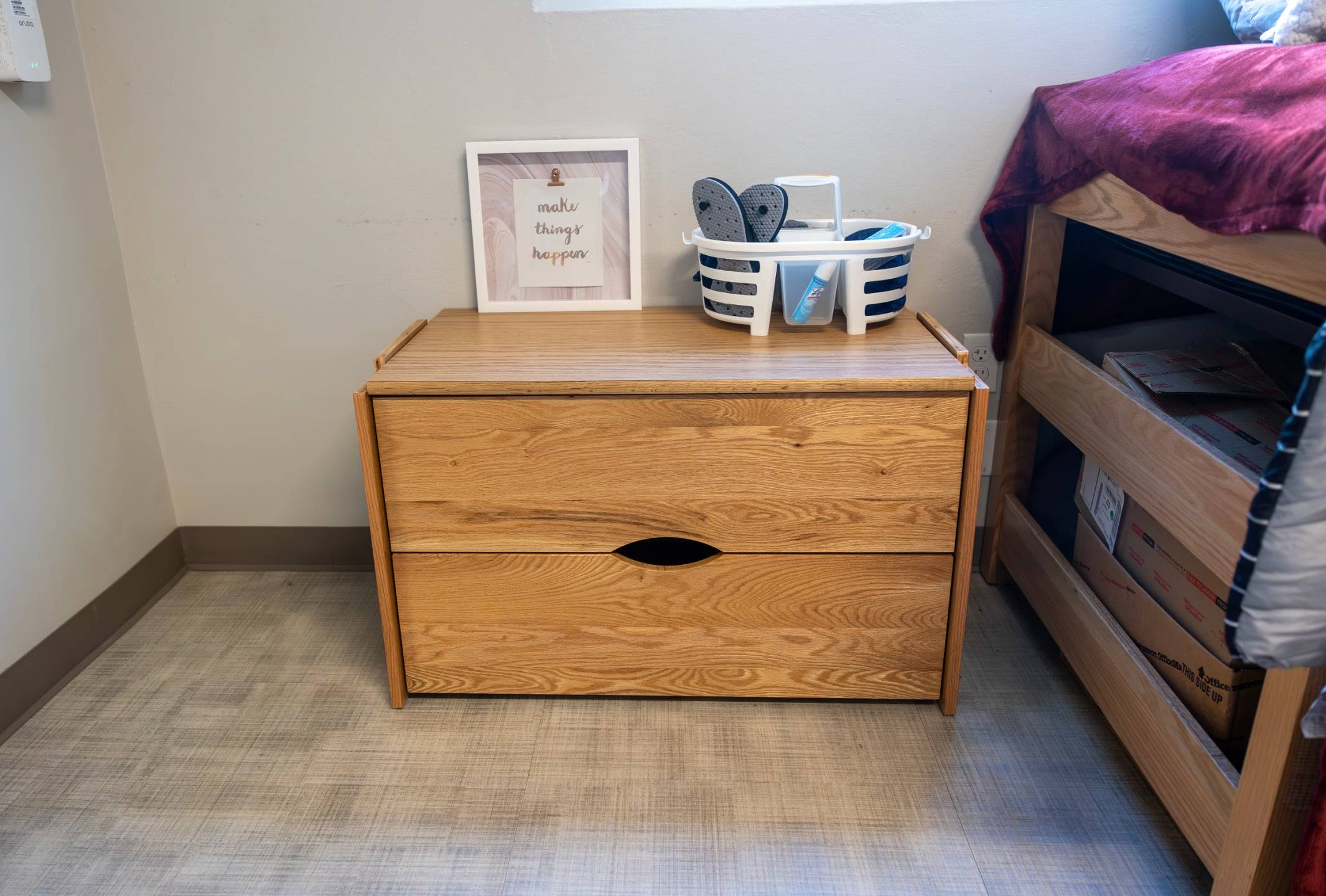 a wooden chest with a picture frame and a basket on top