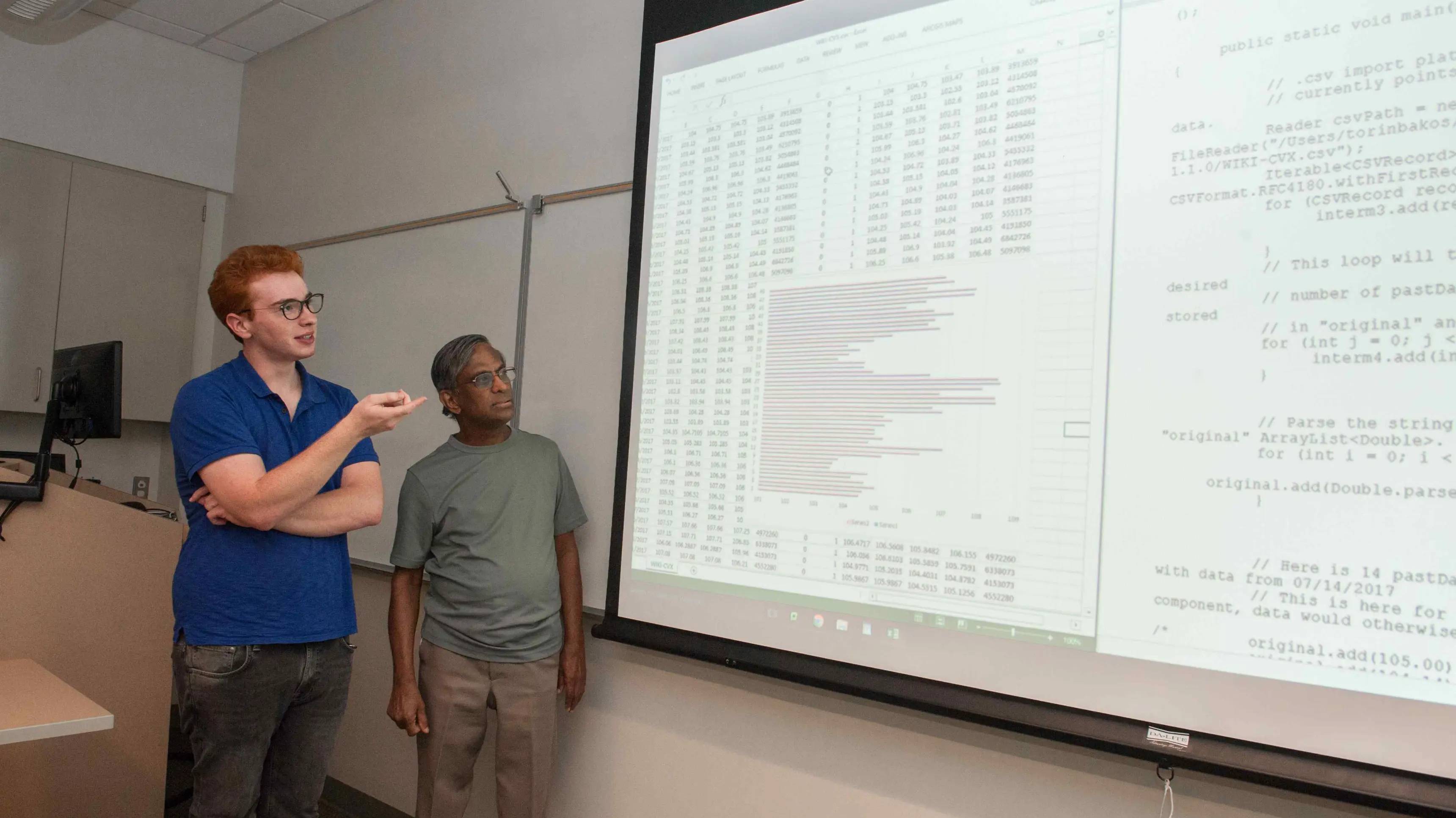 a person standing next to a large screen