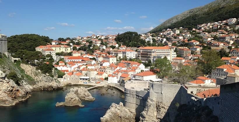 a city with red roofs and a body of water