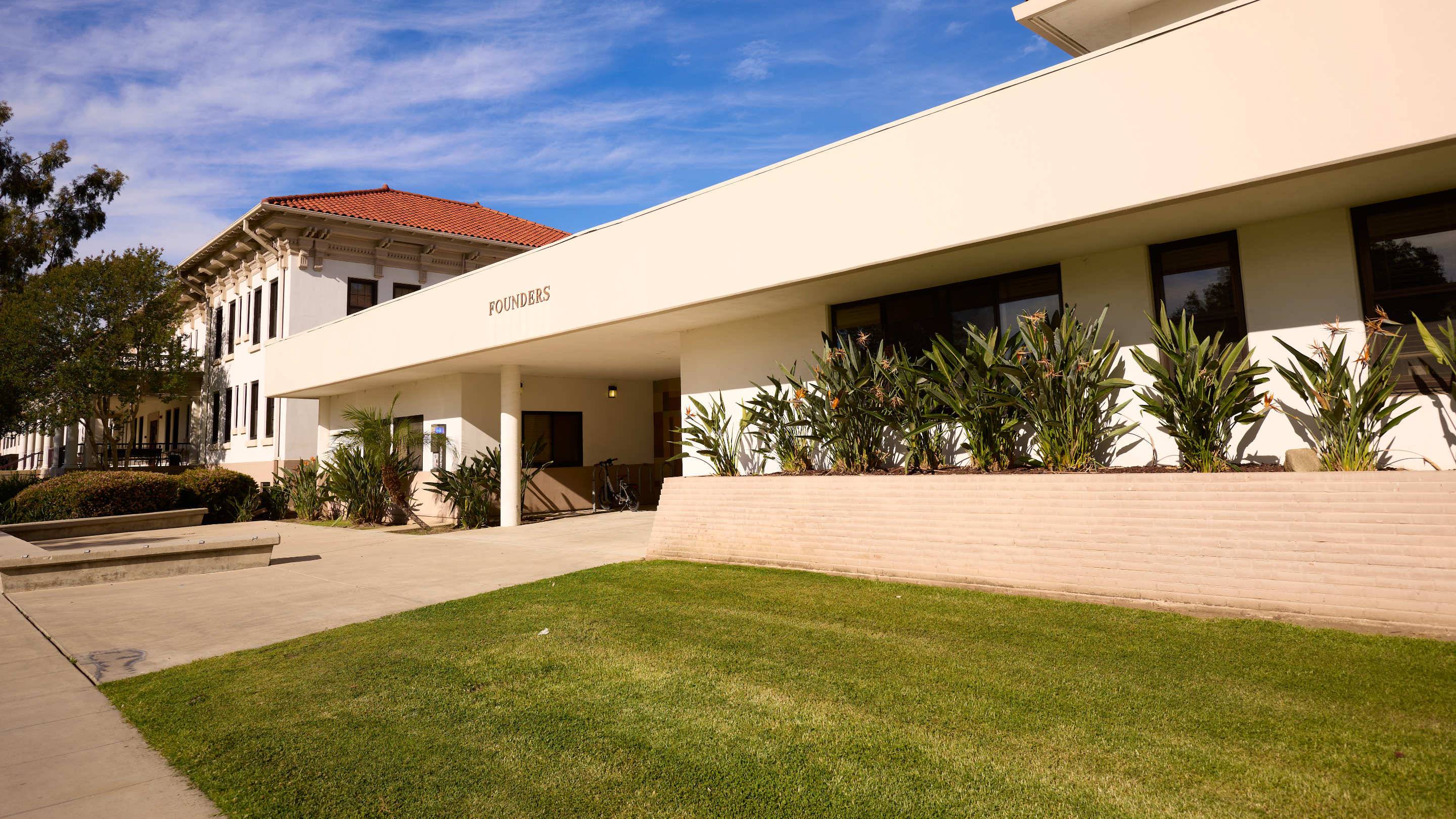 a building with a lawn and a building with a red roof