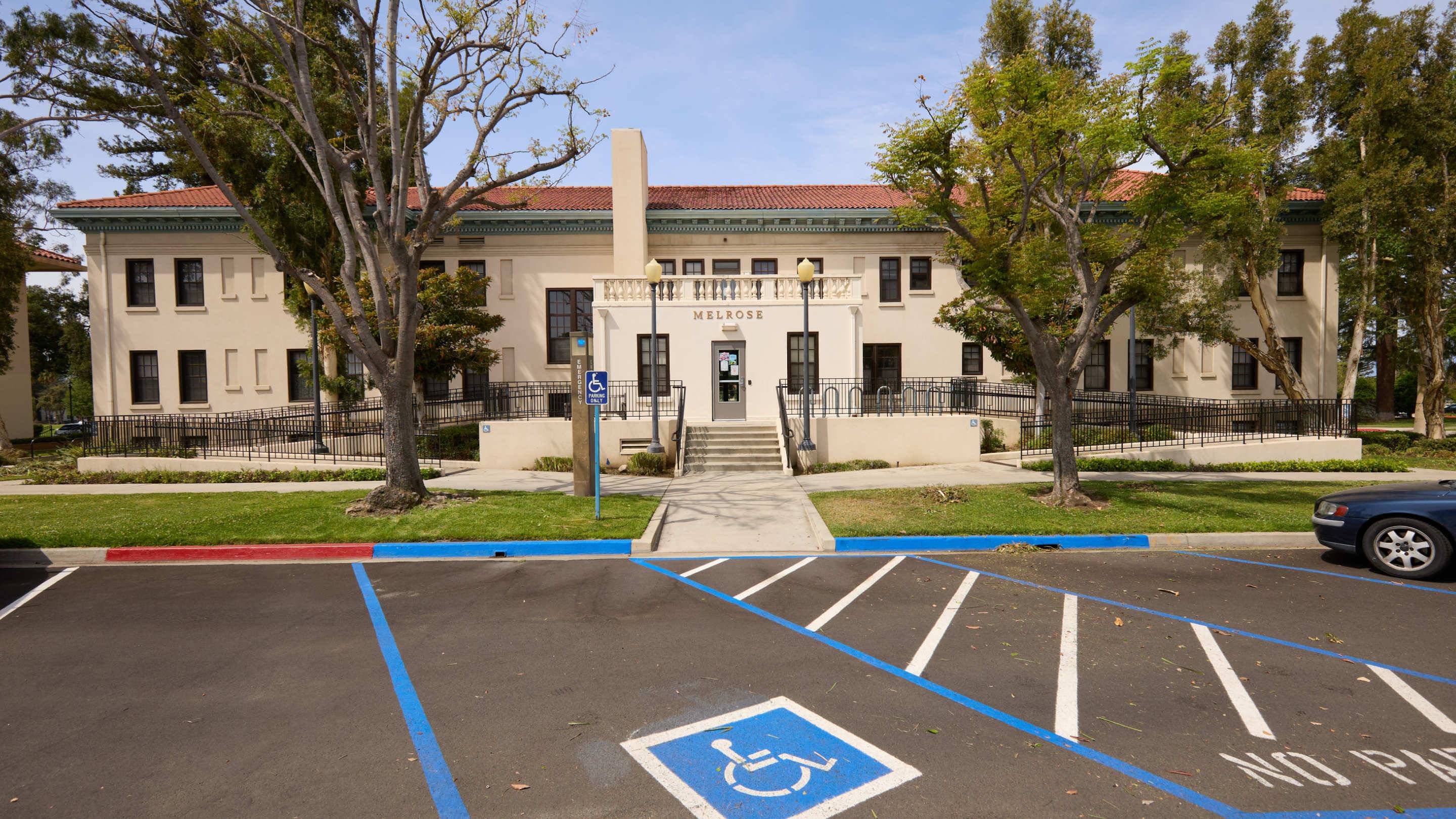a parking lot with a building and trees
