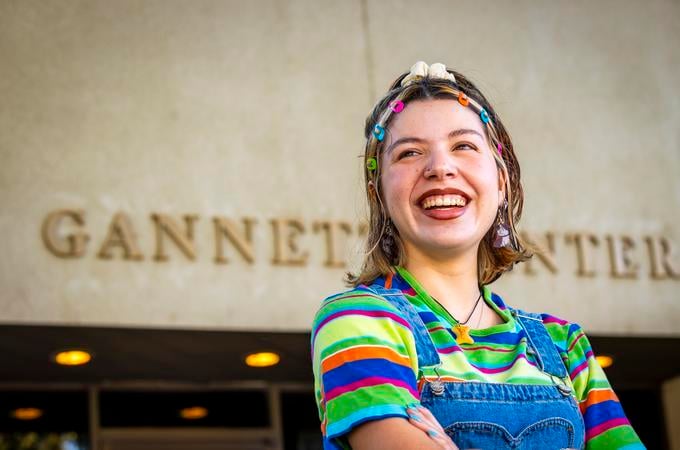 a person smiling with colorful hair
