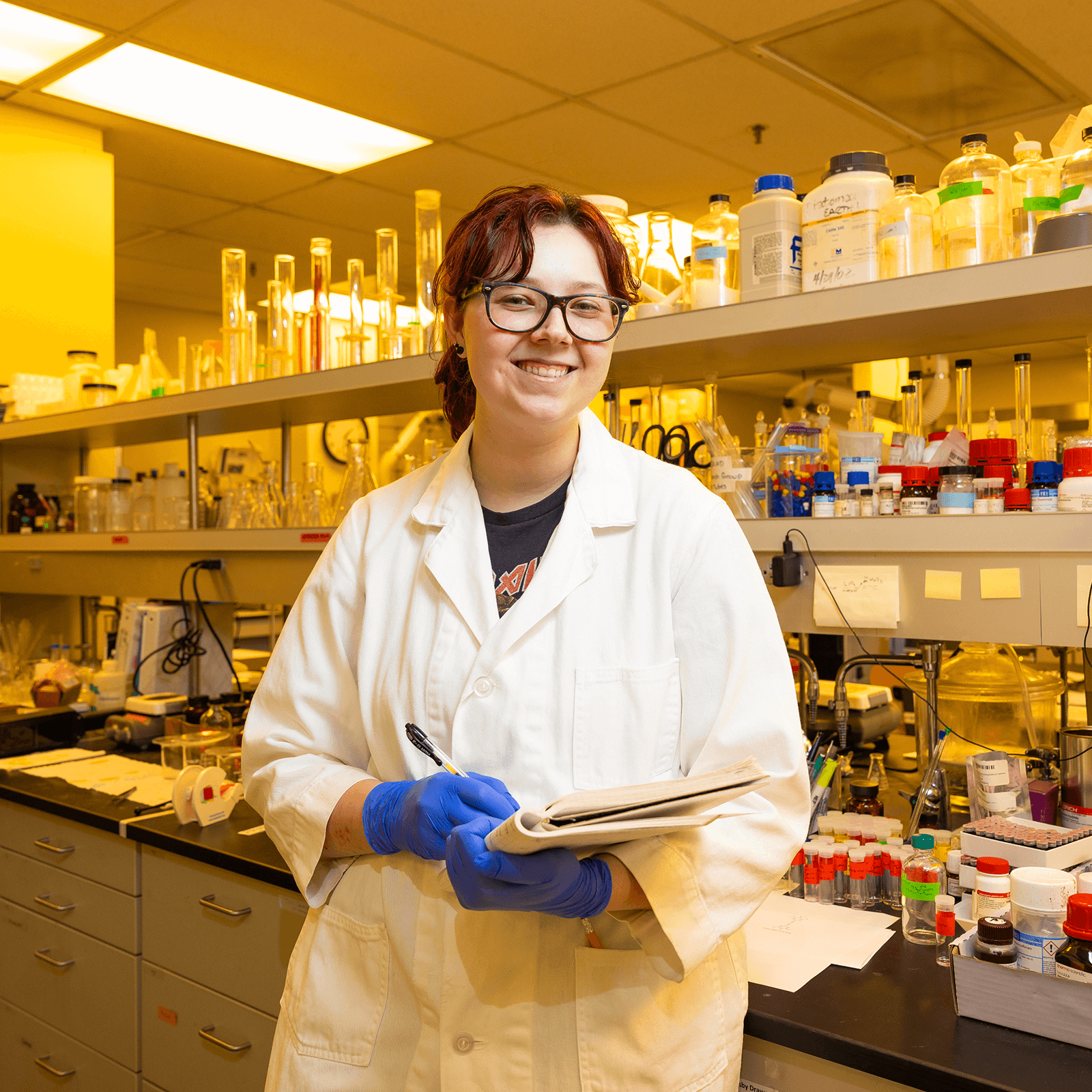 An undergraduate student in a lab coat