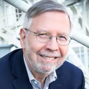 a man wearing glasses and a suit