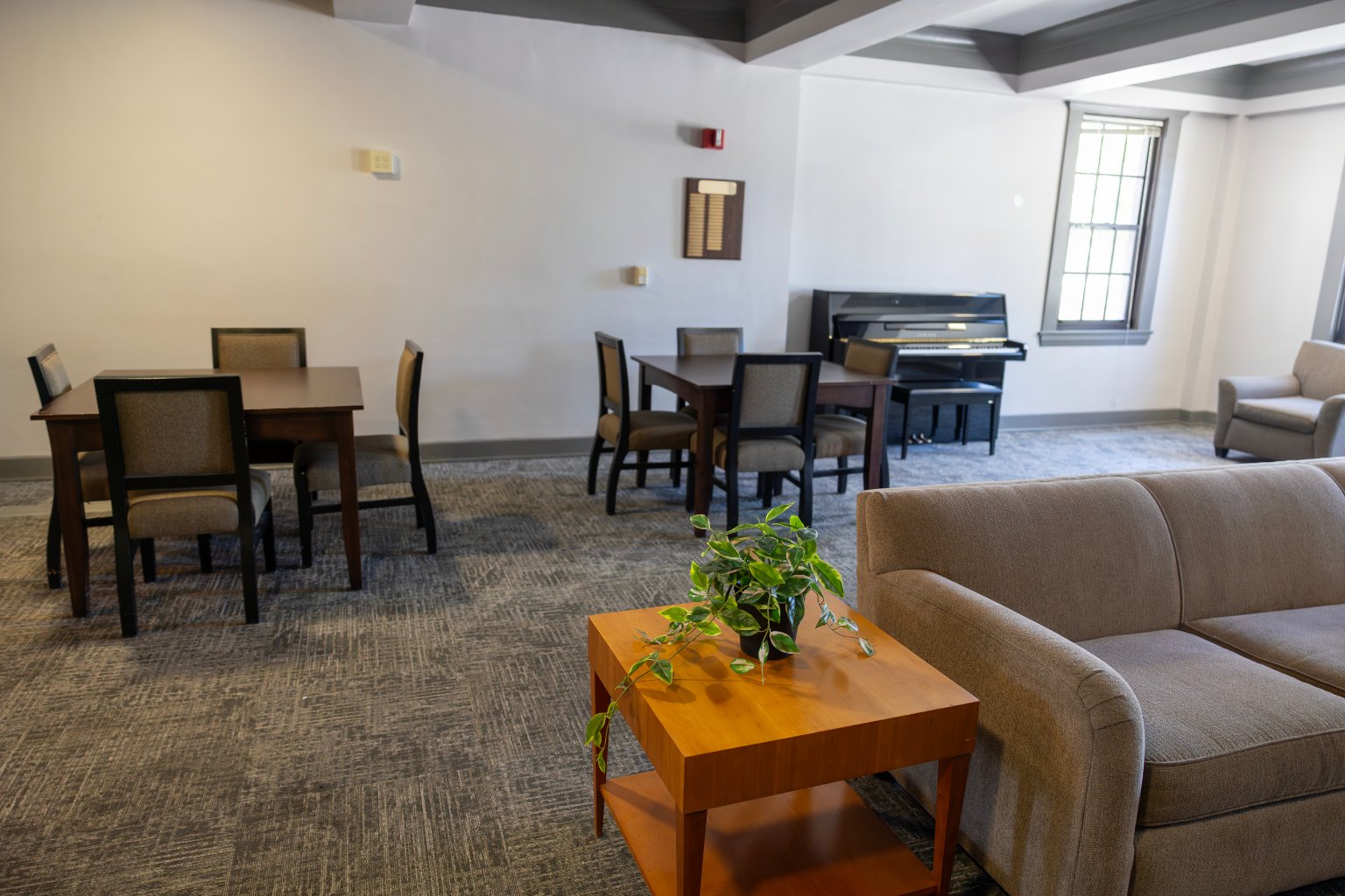 a room with a piano and tables and chairs