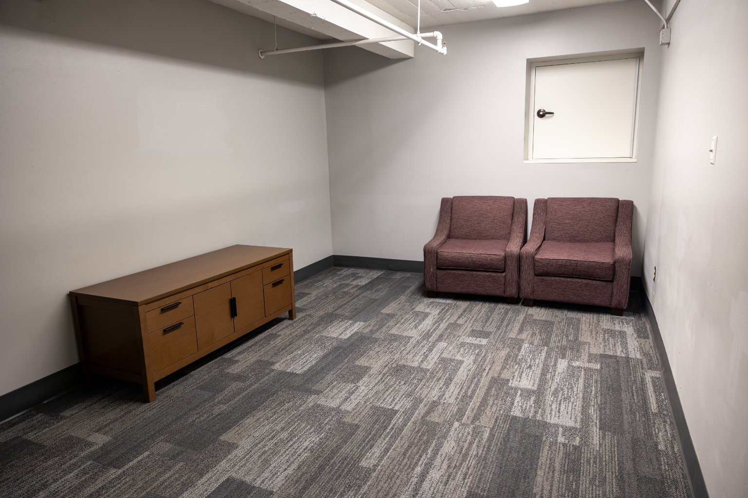 a room with two chairs and a cabinet