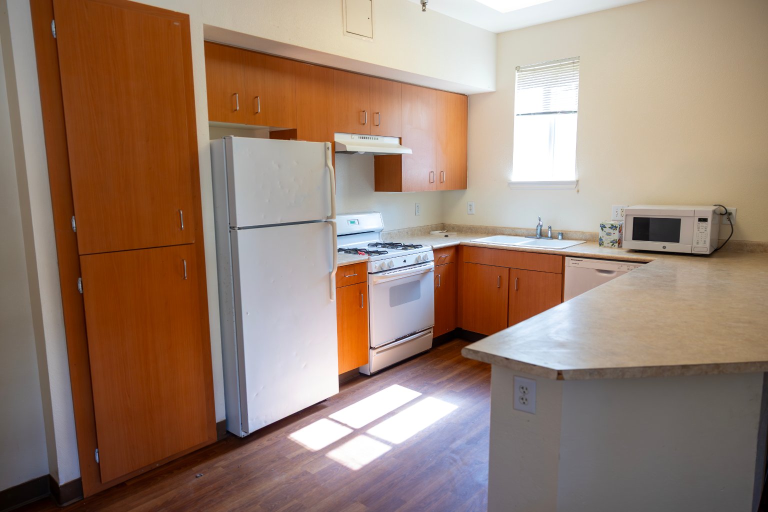 a kitchen with white appliances and wooden cabinets