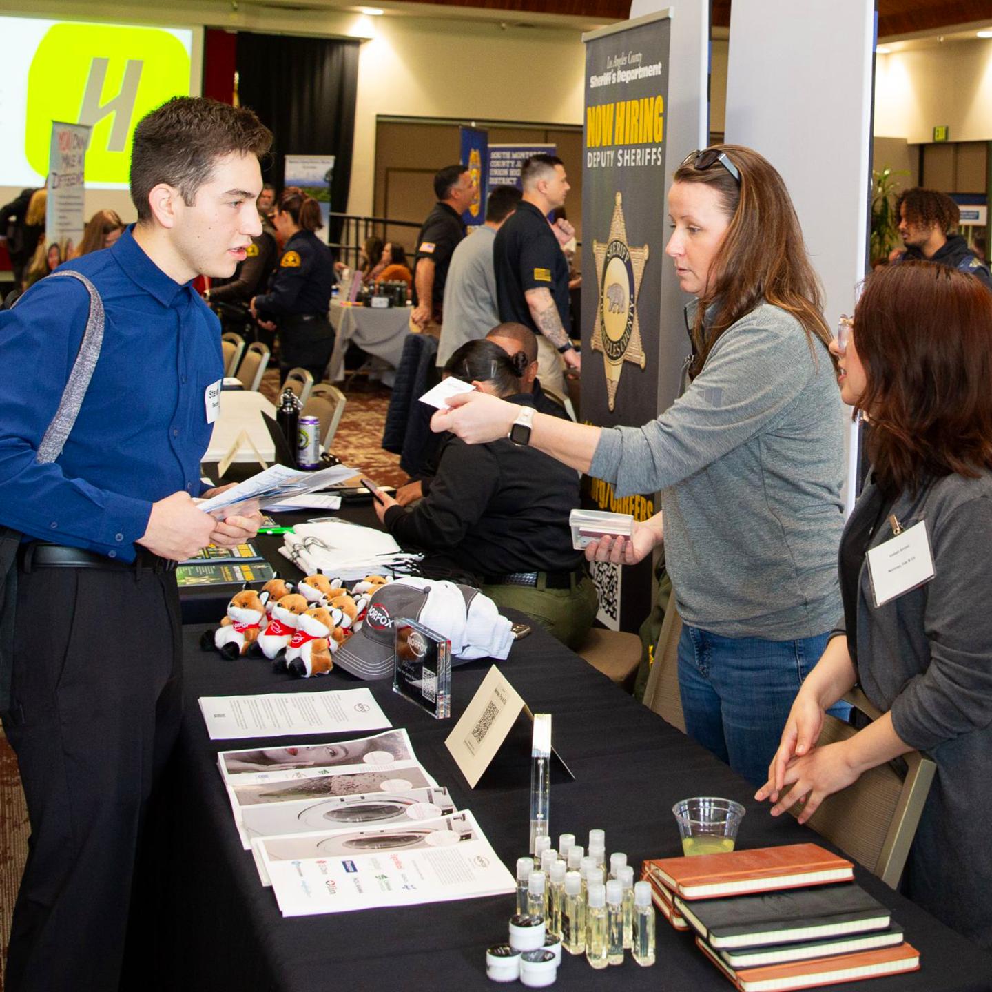 a person standing next to a table with a person standing next to a table with other people