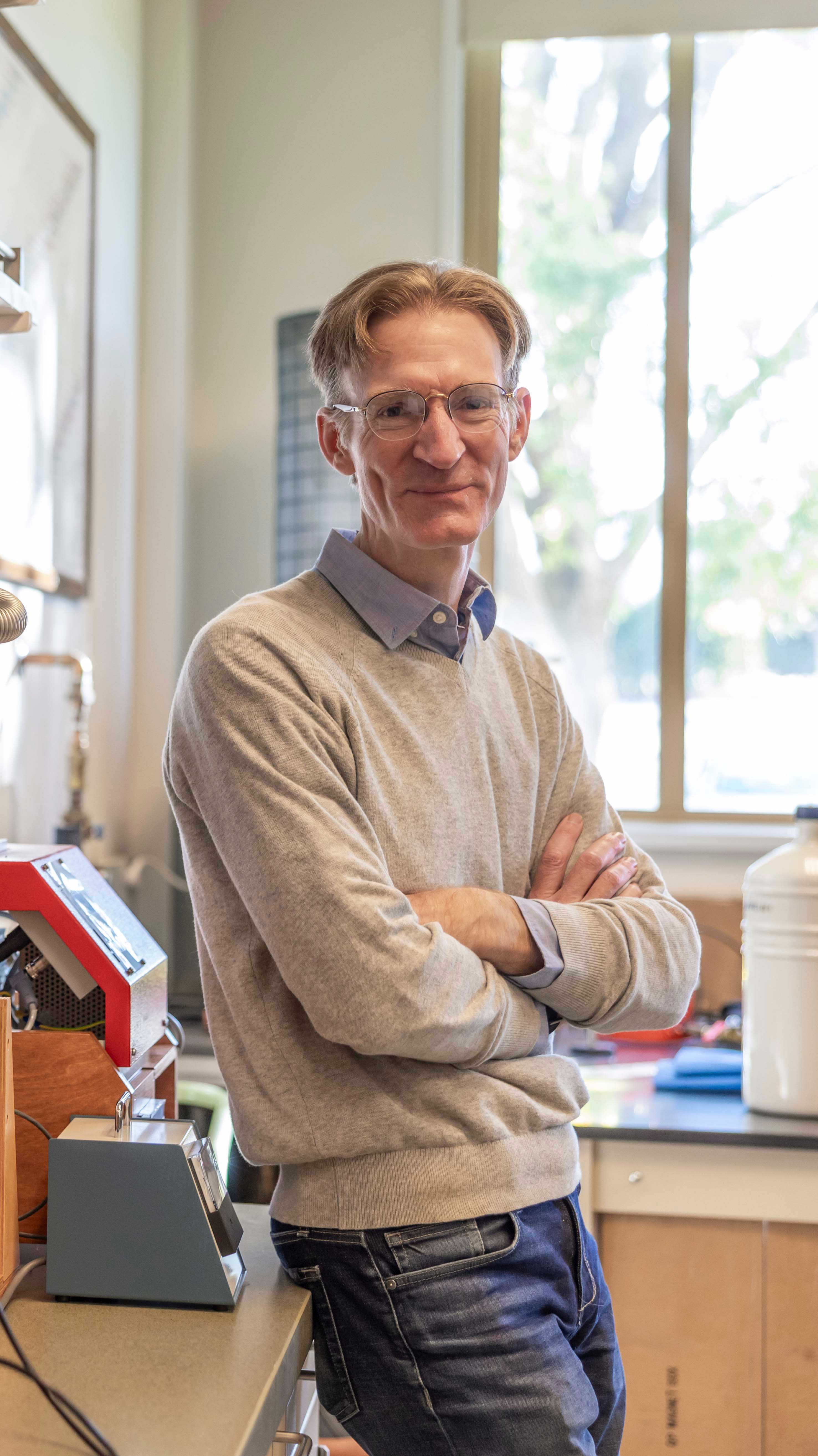 a person with glasses and a sweater with his arms crossed