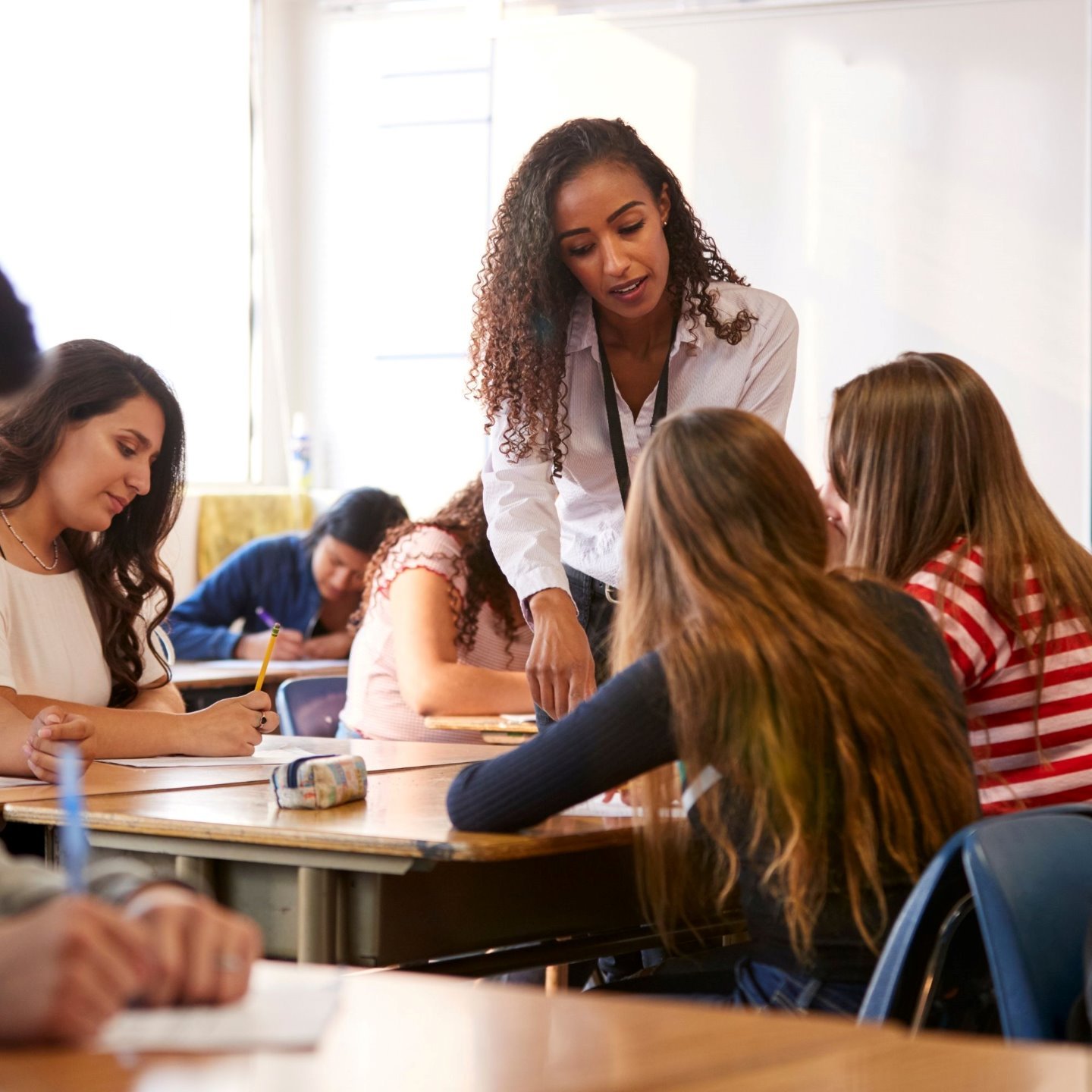 a woman standing in front of a group of students