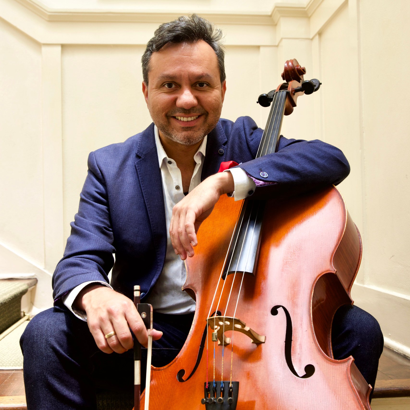 a person sitting on stairs holding a cello