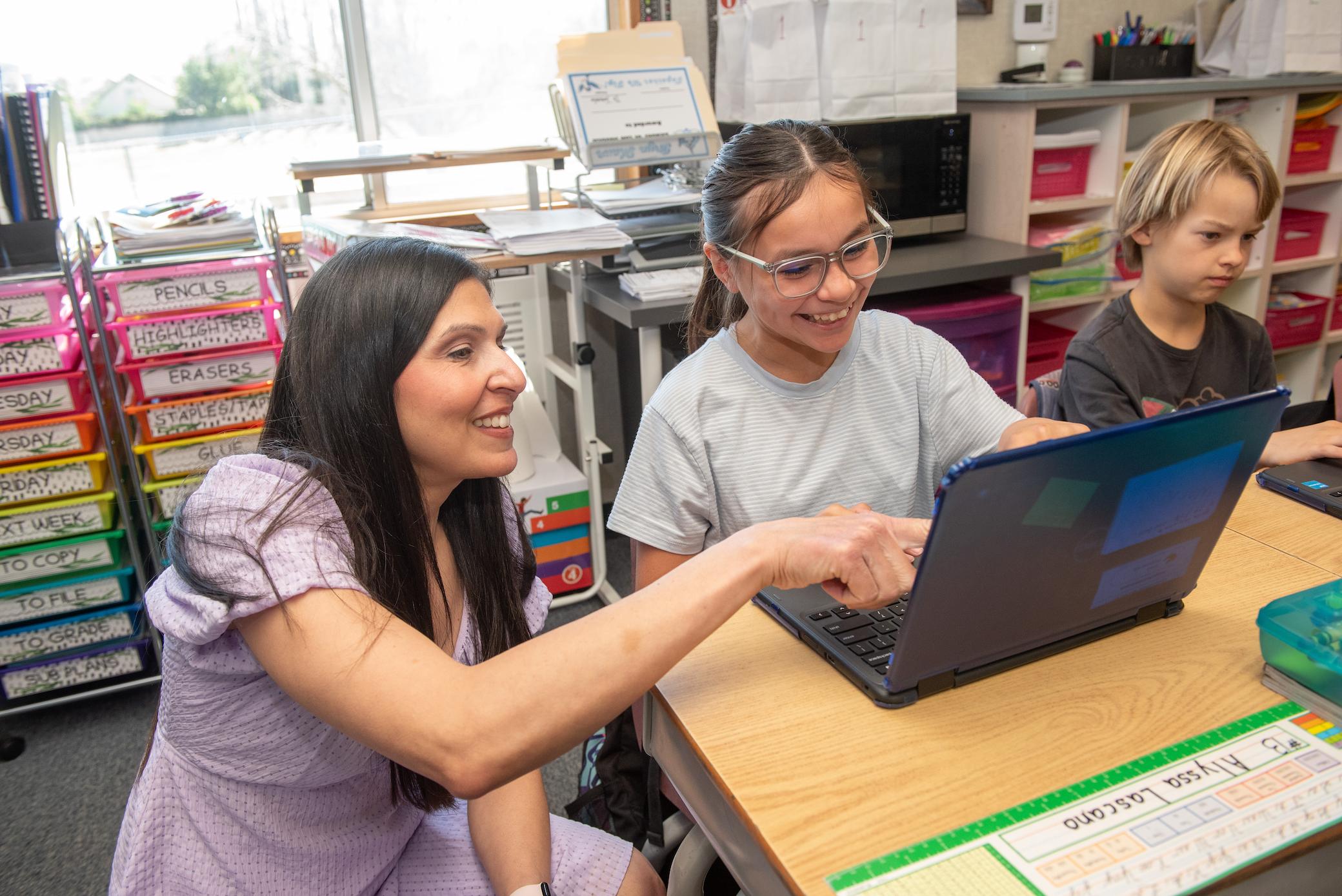 a woman pointing at a laptop