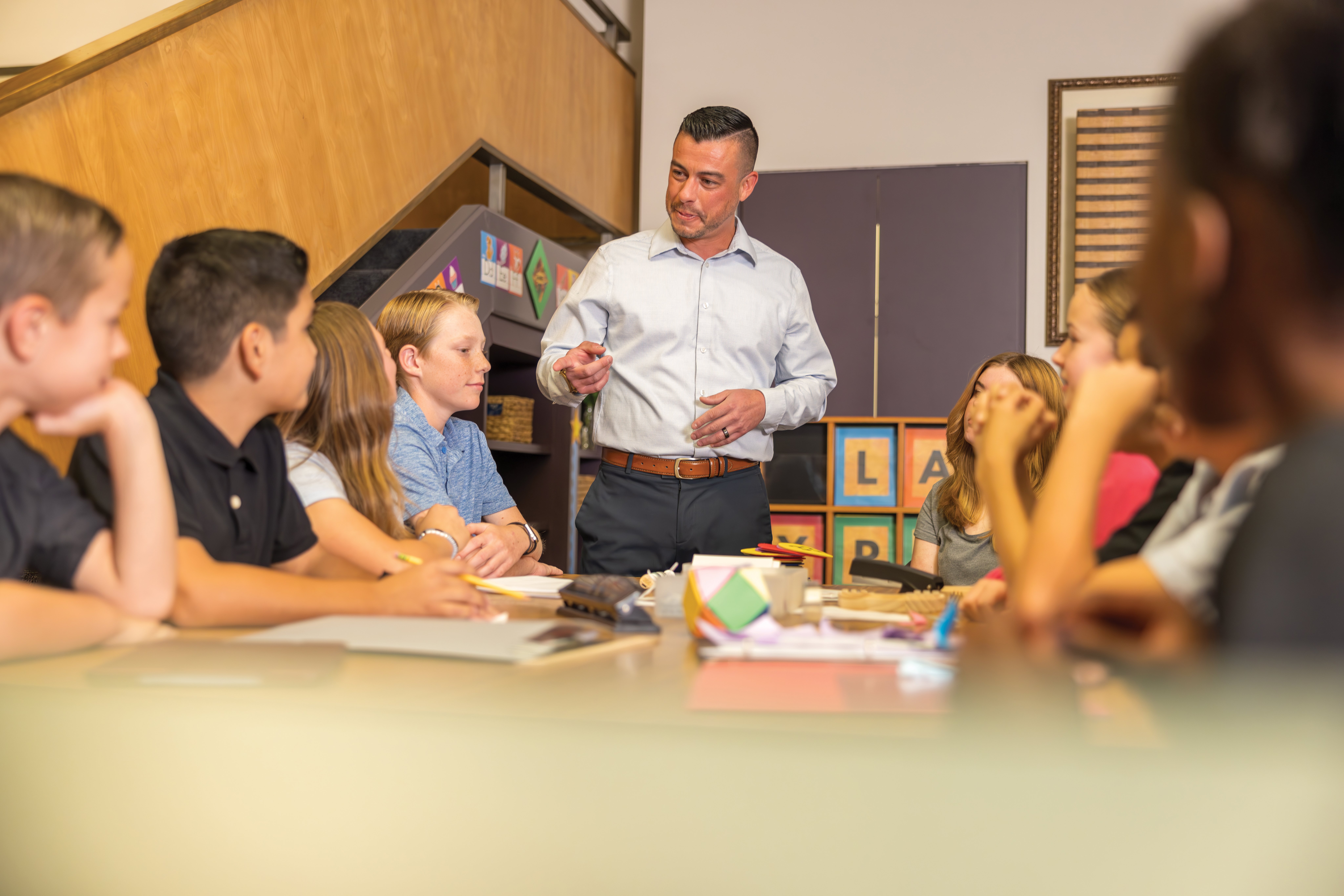 students interacting with instructor at conference table