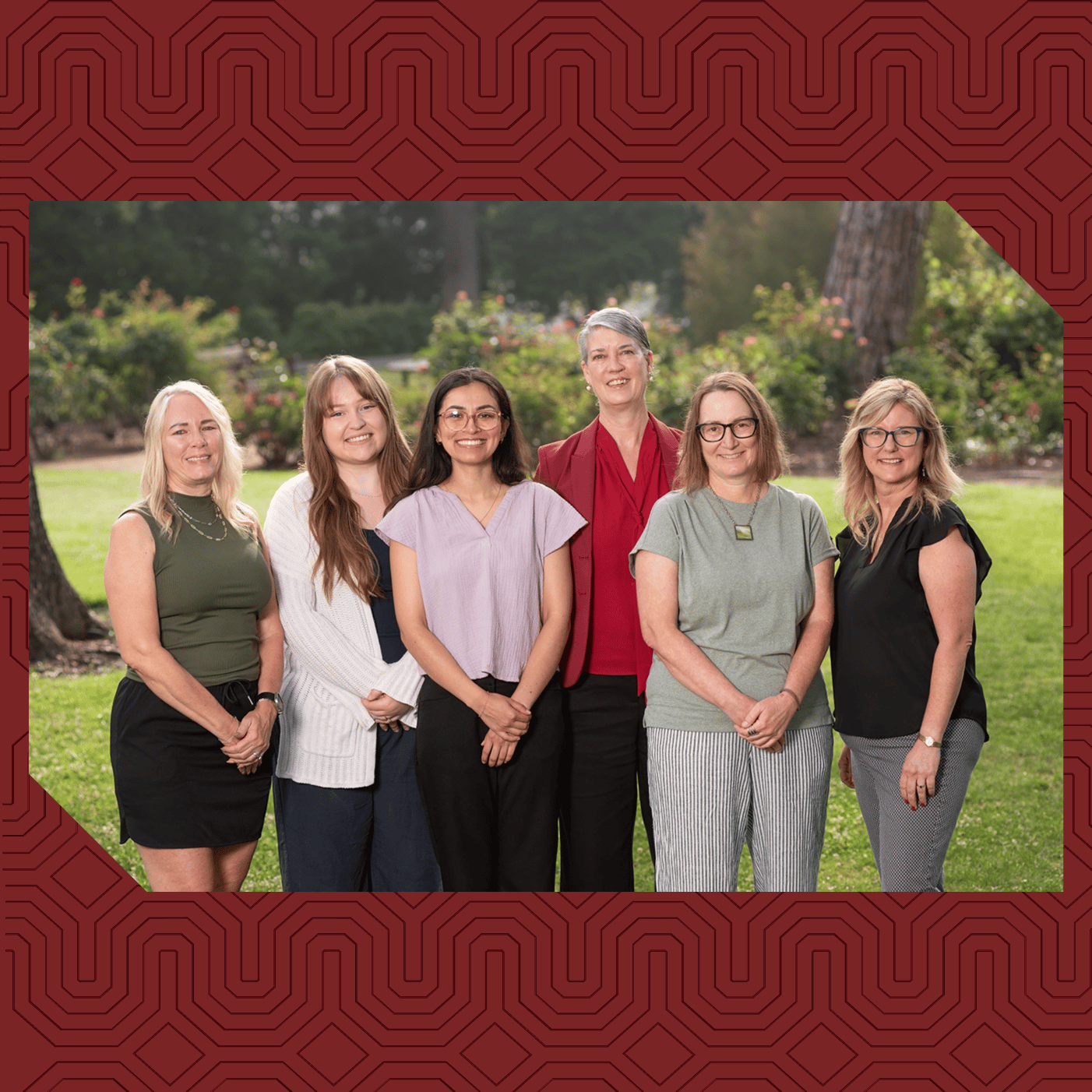 a group of women standing together in a park