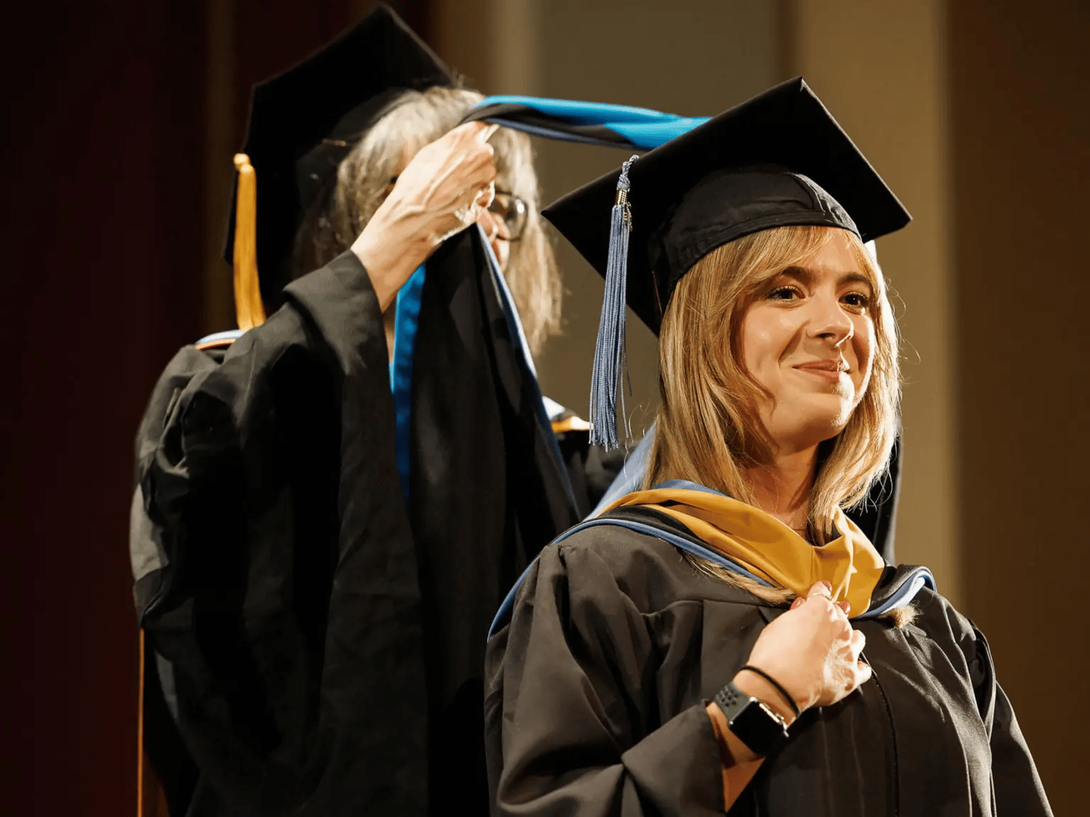 a woman in a graduation gown and cap