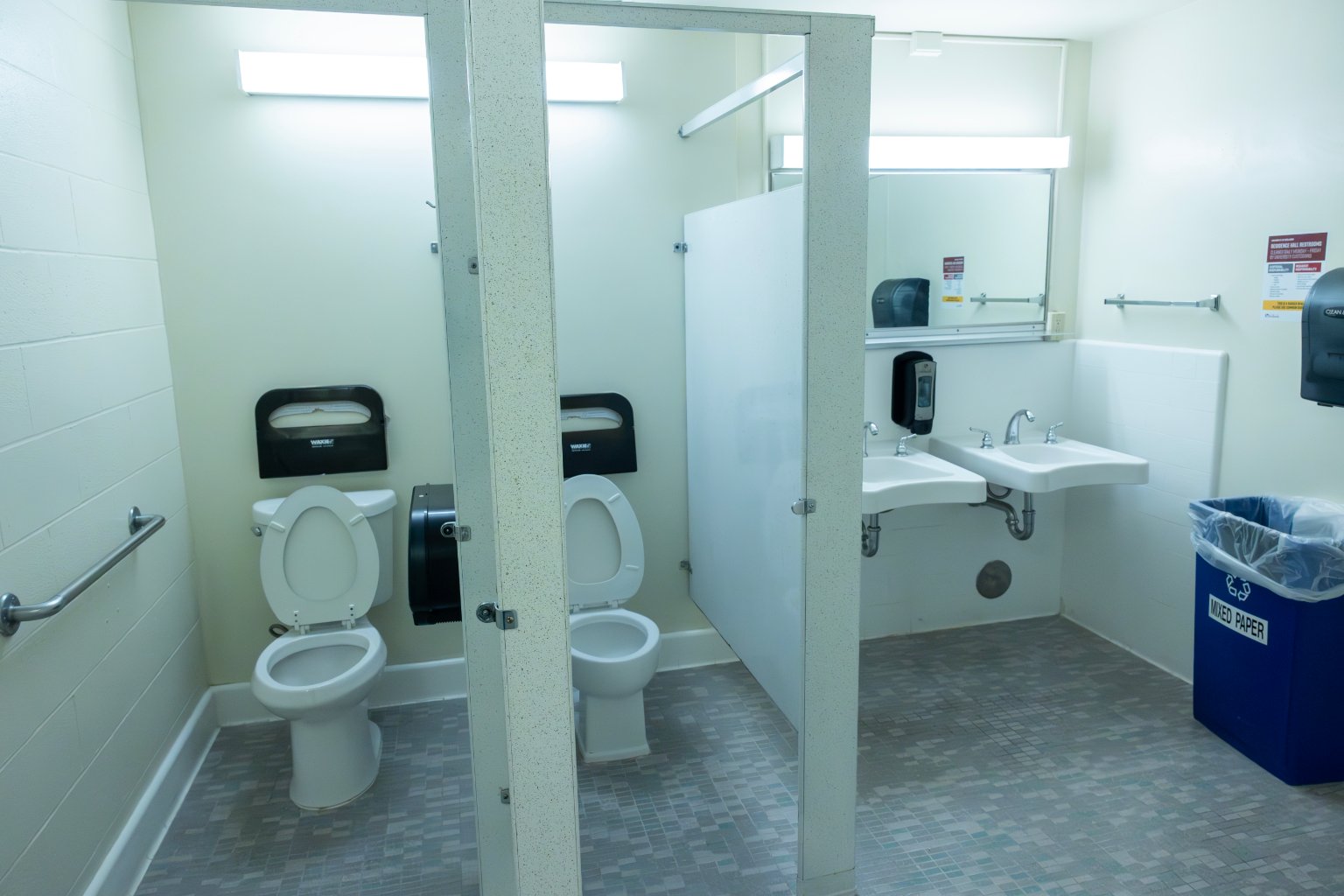 a bathroom with two toilets and sinks