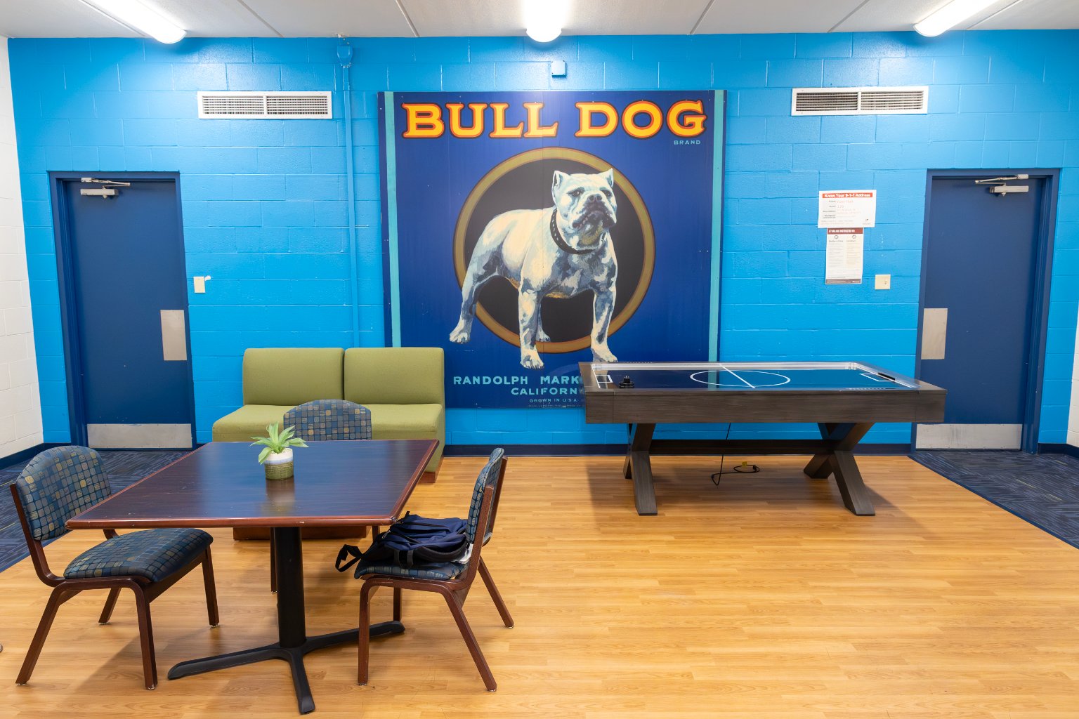 a room with a table and chairs and a poster on the wall