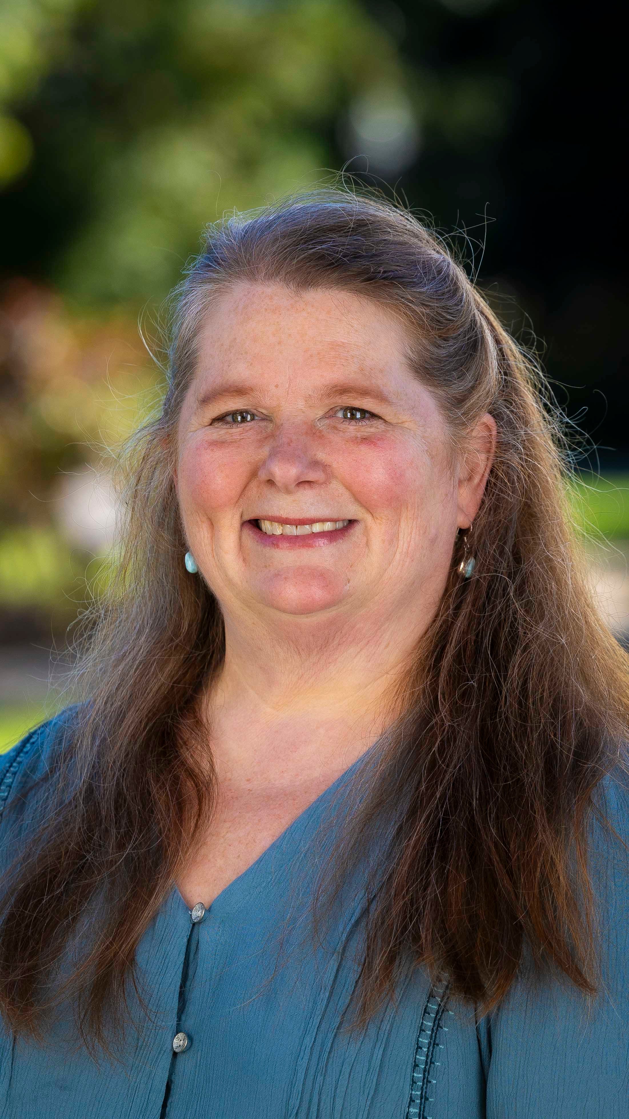 a person with long hair smiling