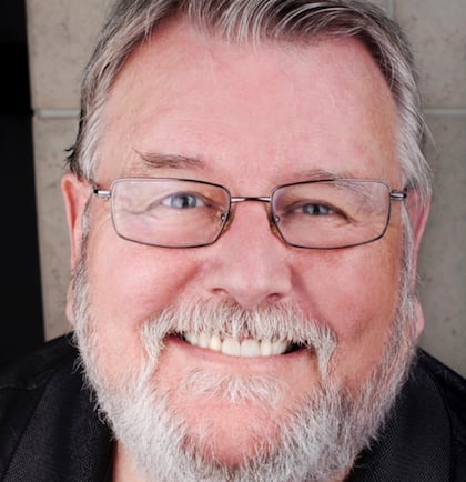 a person with glasses smiling