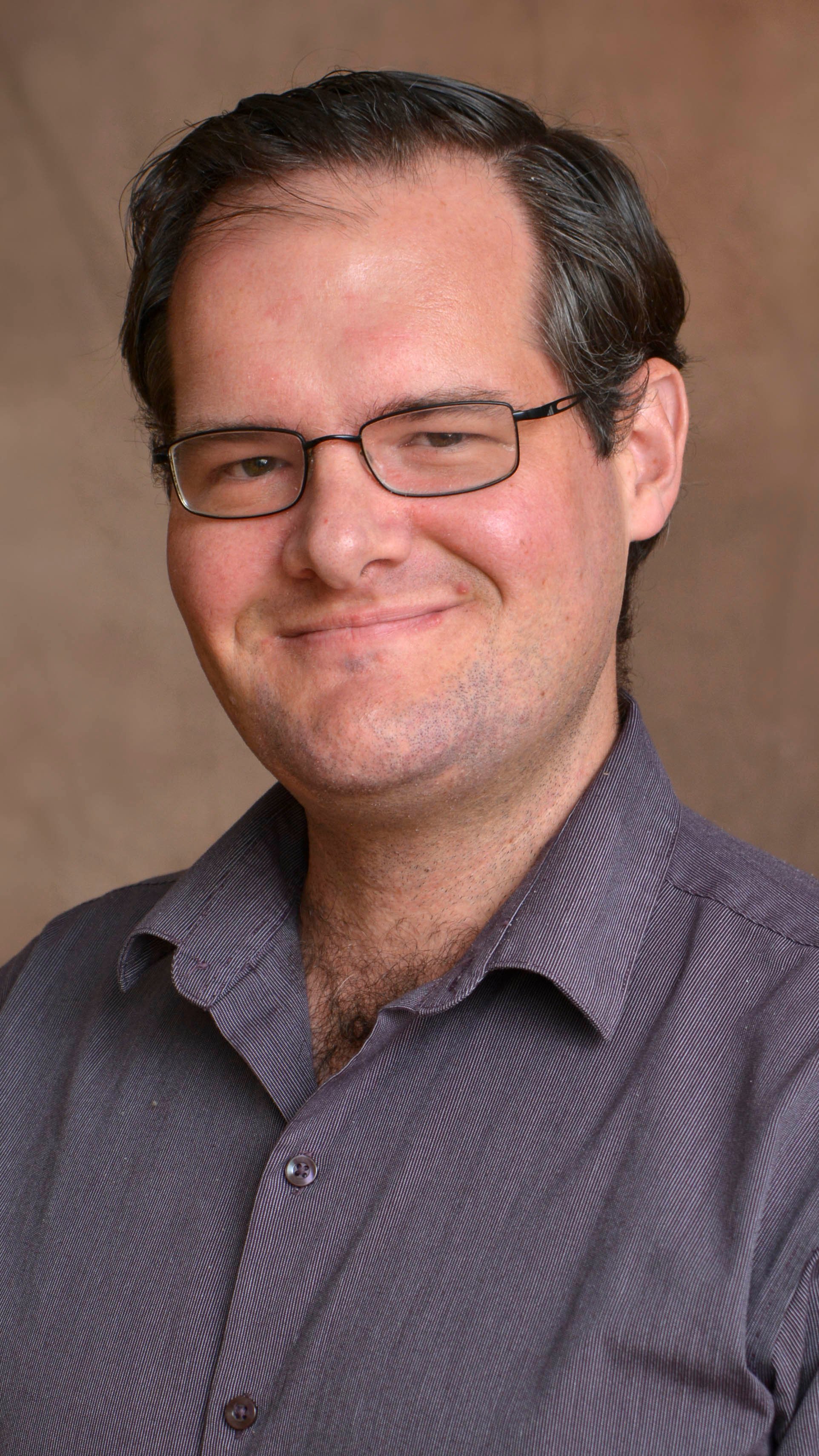 a man wearing glasses and a striped shirt