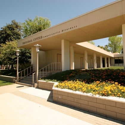 a building with a walkway and flowers