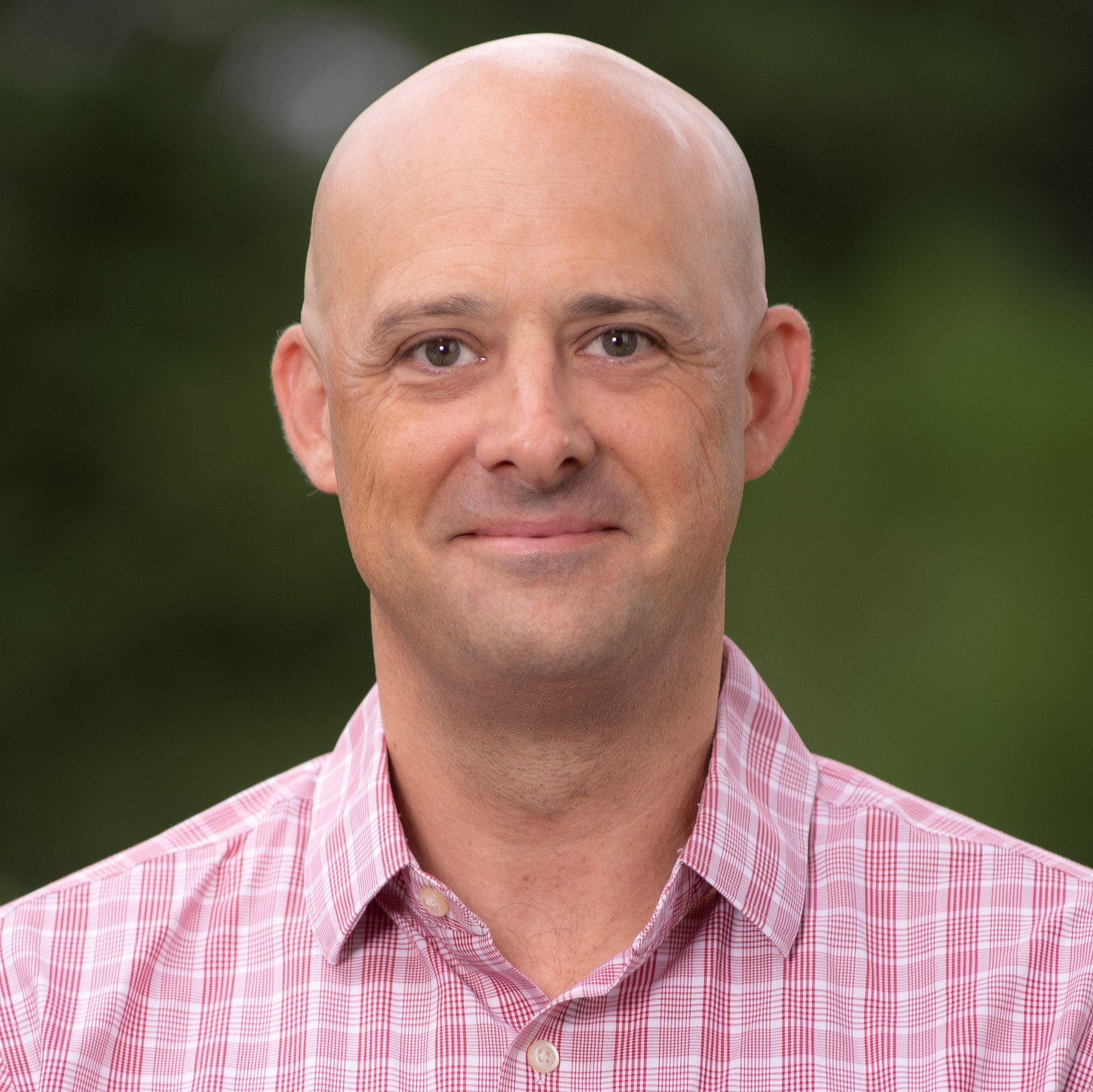 a bald man in a red and white checked shirt