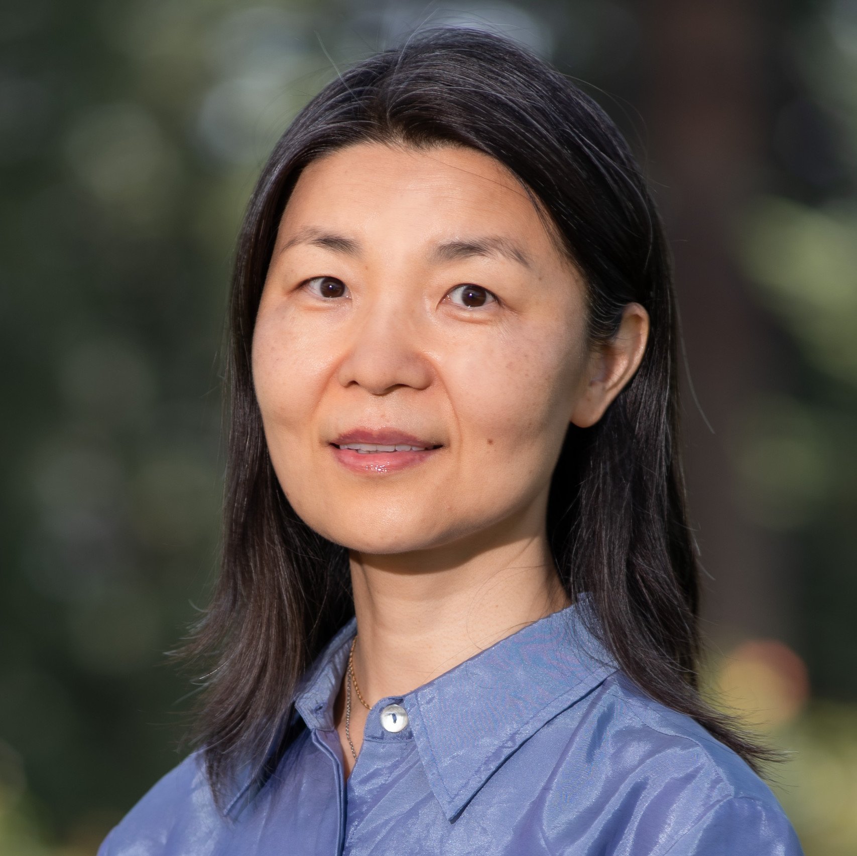 a person with dark hair wearing a blue shirt