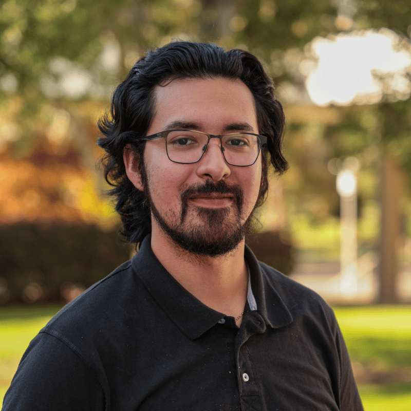 a person with glasses and beard wearing a black shirt