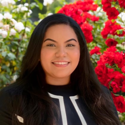 a person smiling in front of flowers