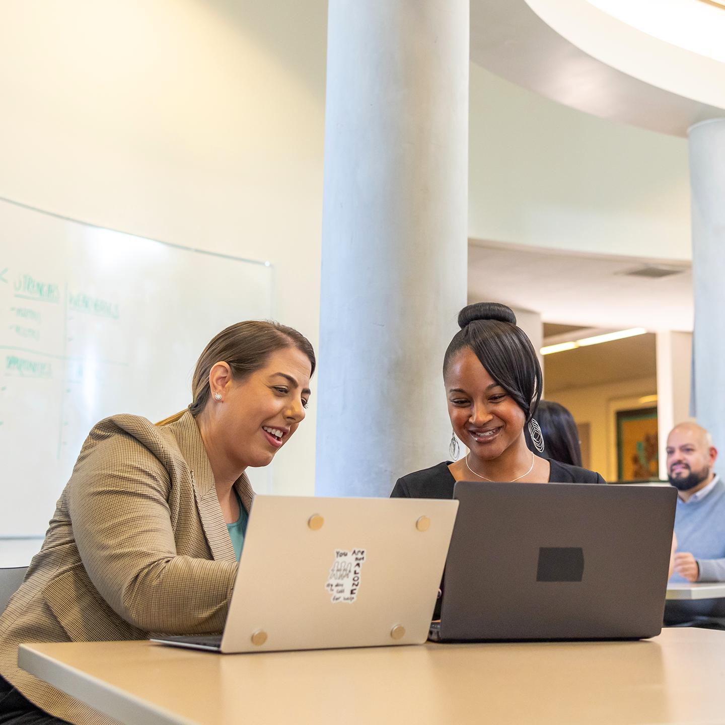 a group of women looking at laptops