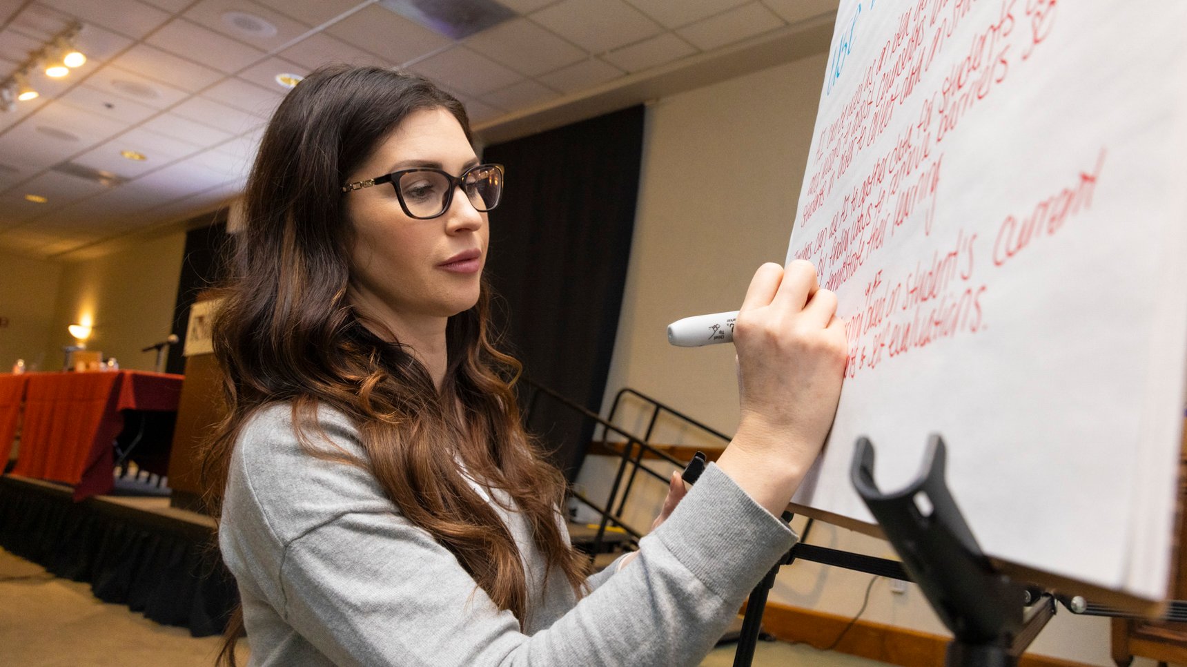 a woman writing on a white board
