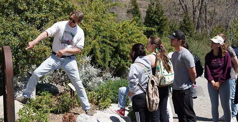 a man standing on a rock with a group of people around him