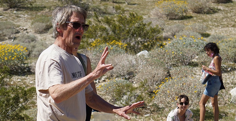 a man in sunglasses standing in front of a group of people