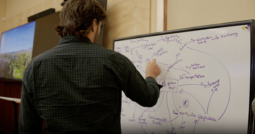 a man writing on a whiteboard