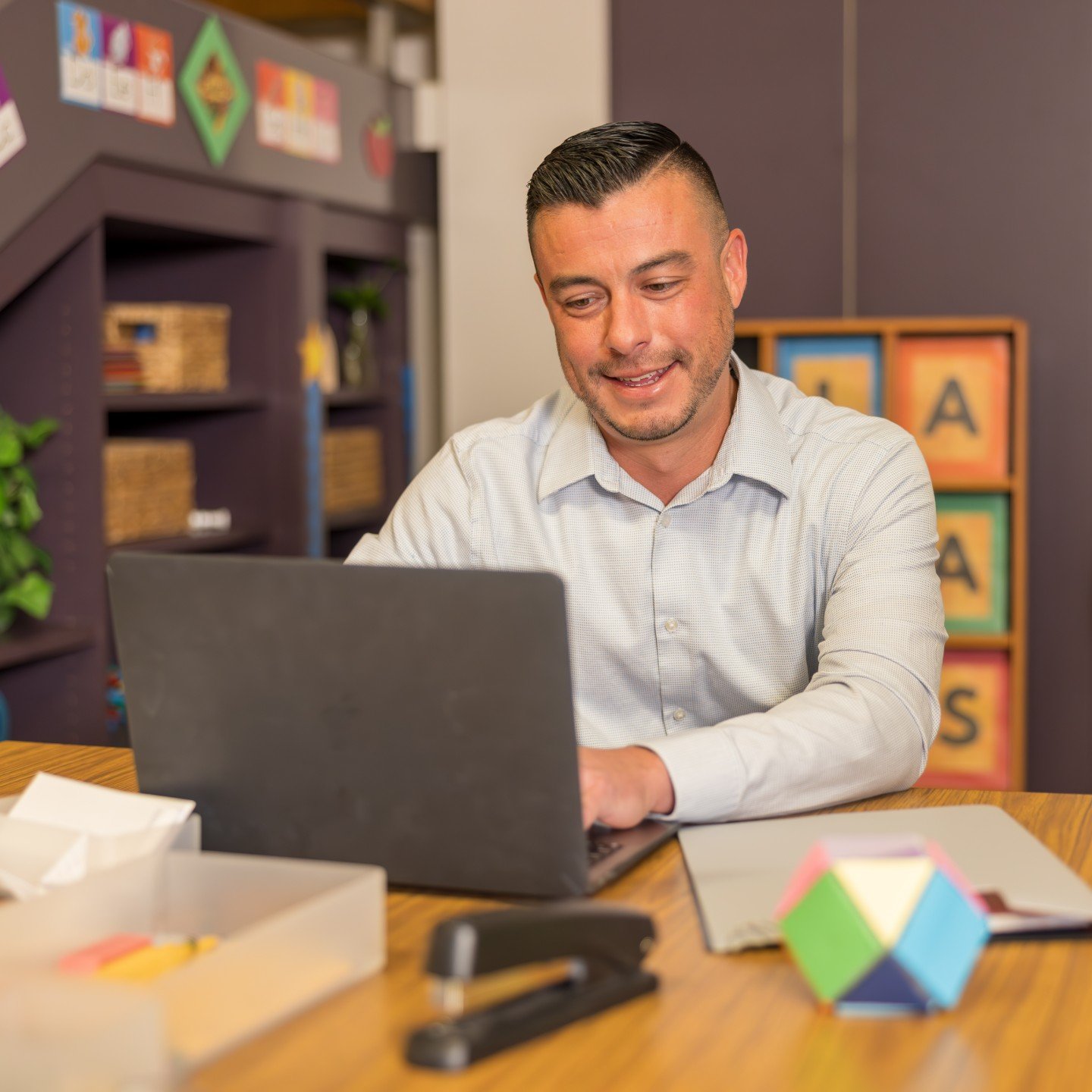 a man sitting at a desk using a laptop