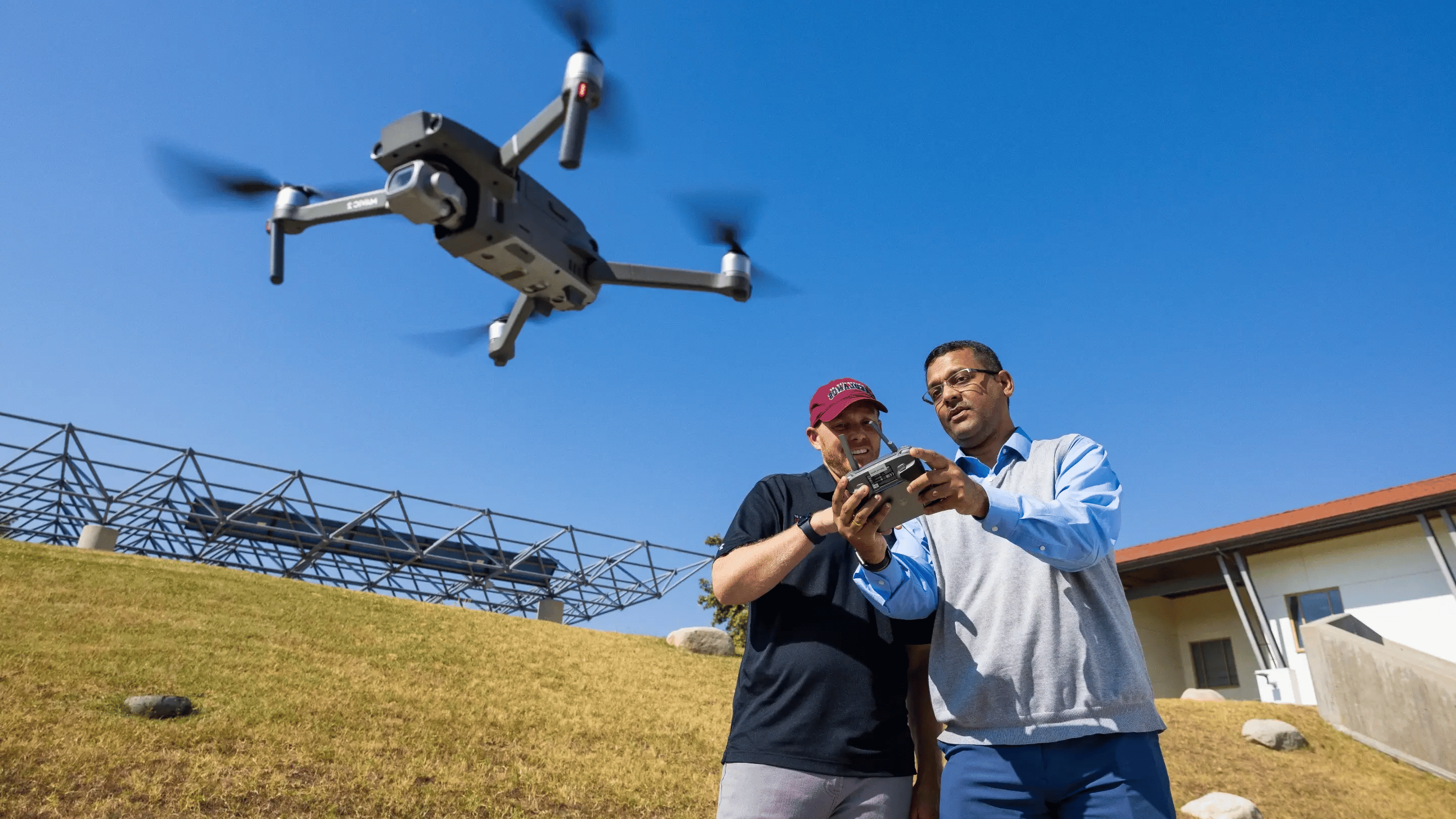 a couple of men flying a drone