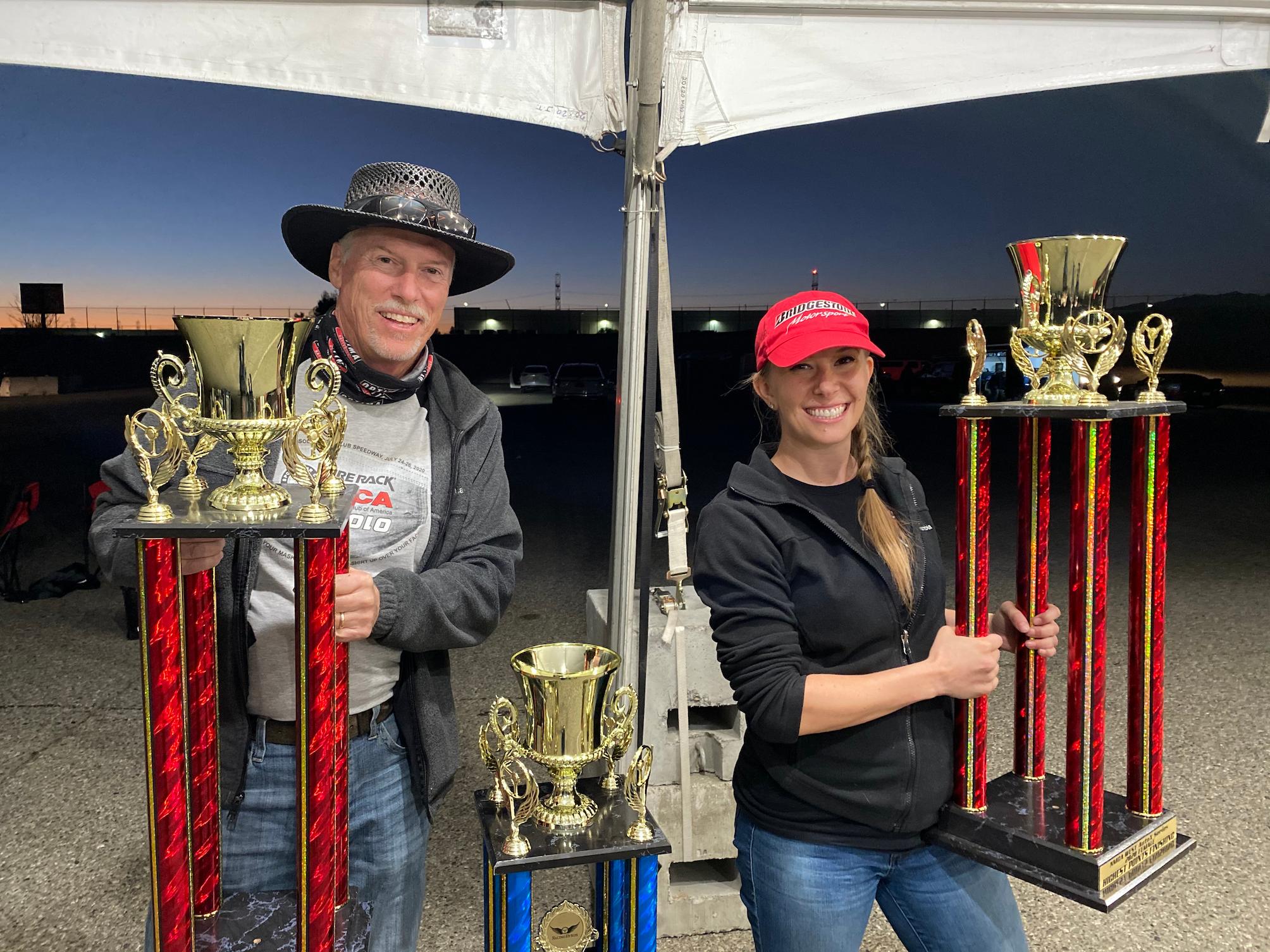 a man and woman holding trophies