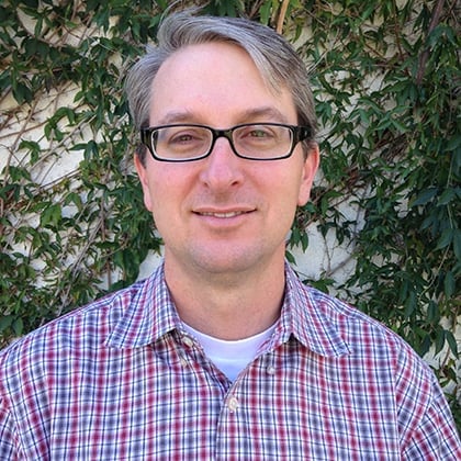 a man wearing glasses and a plaid shirt