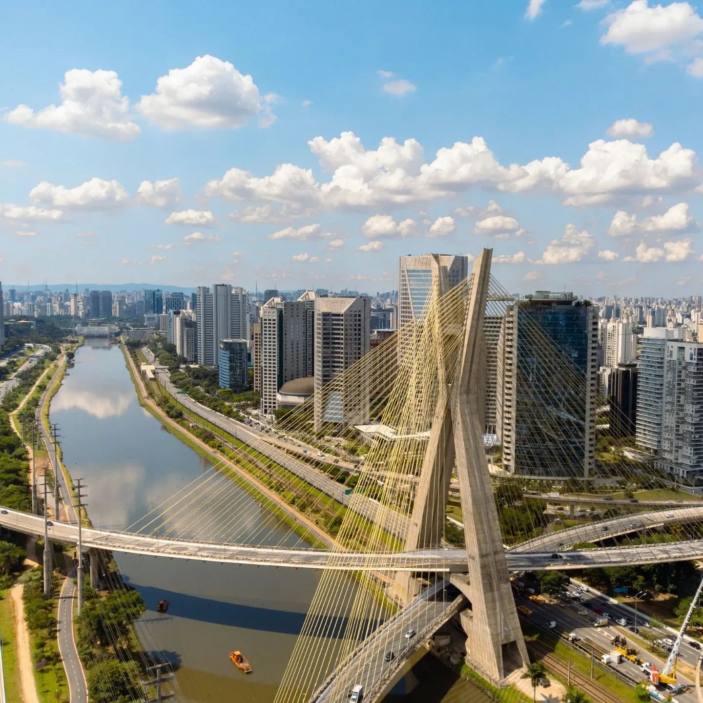 a bridge over a river with a city in the background