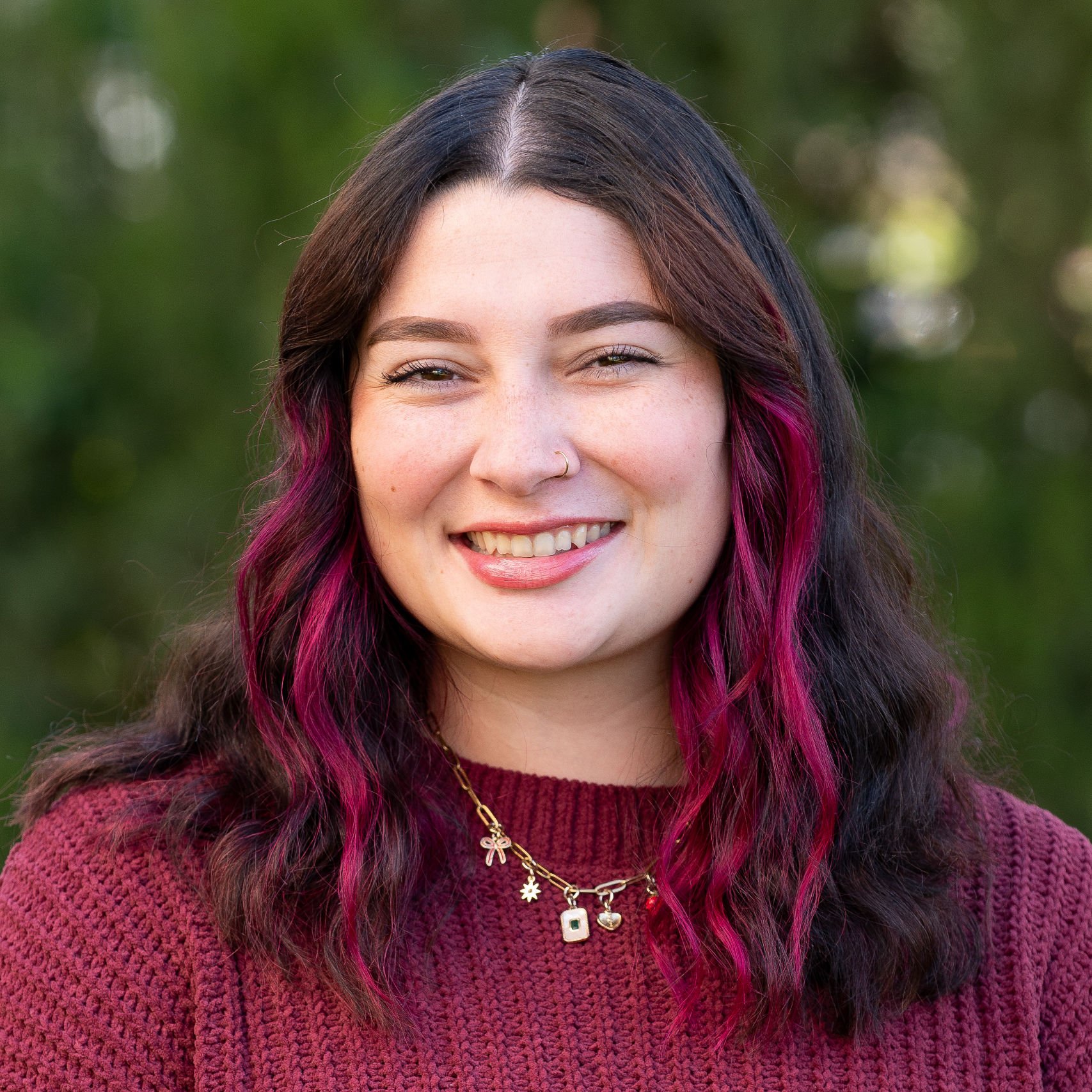 a woman with pink hair smiling