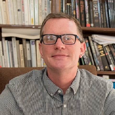 a person wearing glasses and smiling