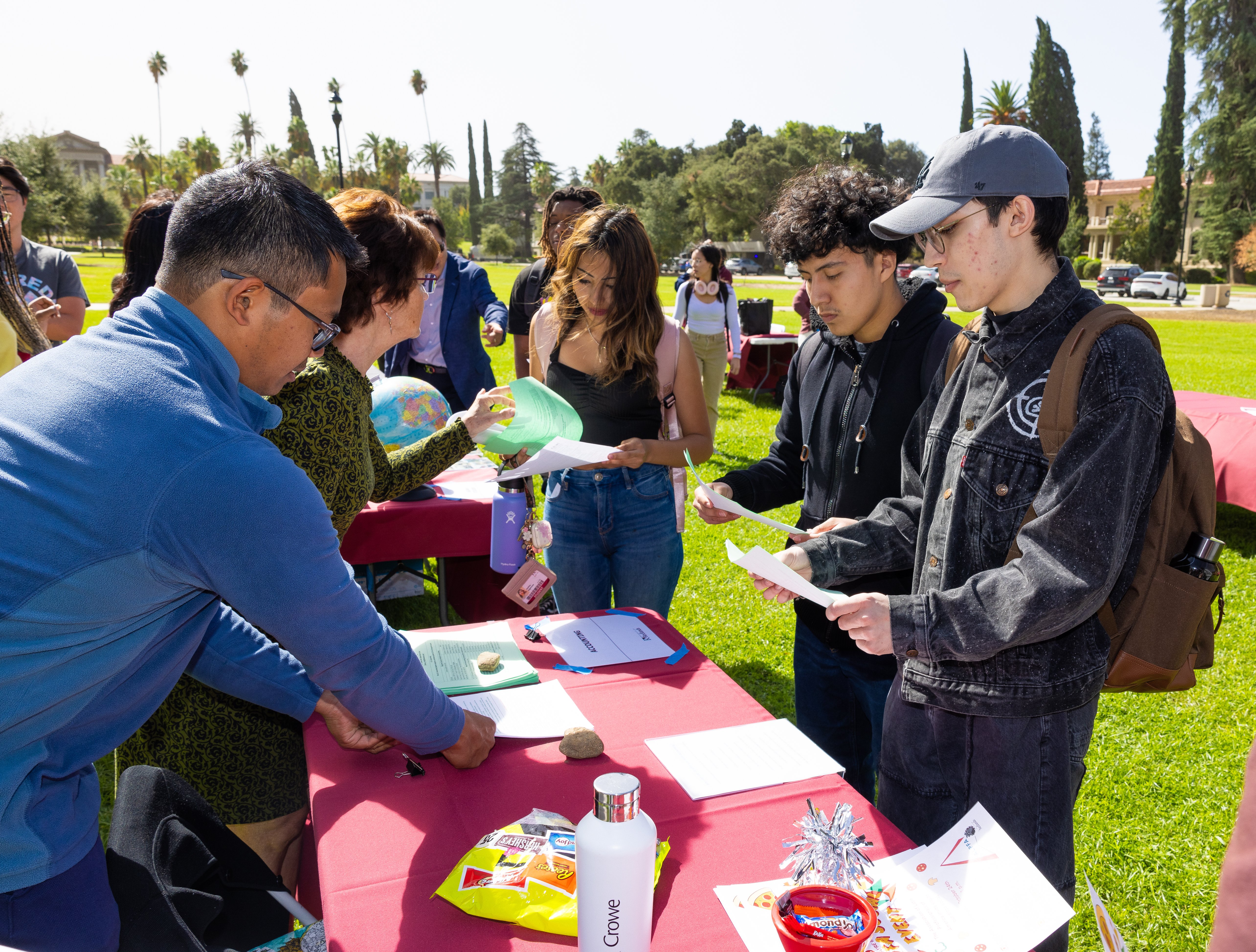 a group of people standing around a table with papers