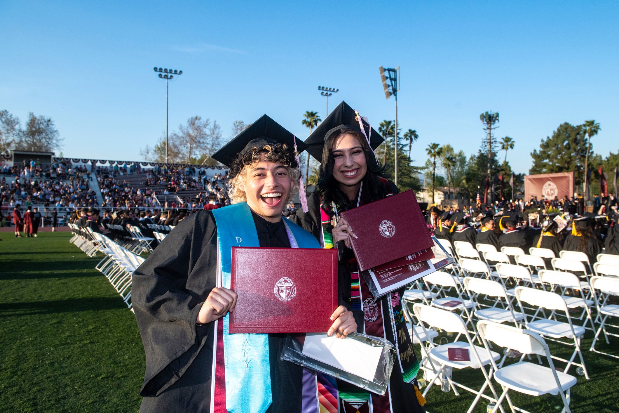 a couple of people in graduation gowns and caps holding diplomas