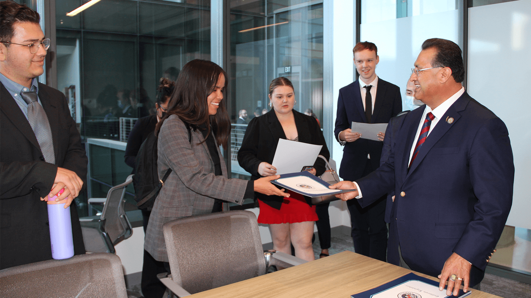 a man handing a document to a woman