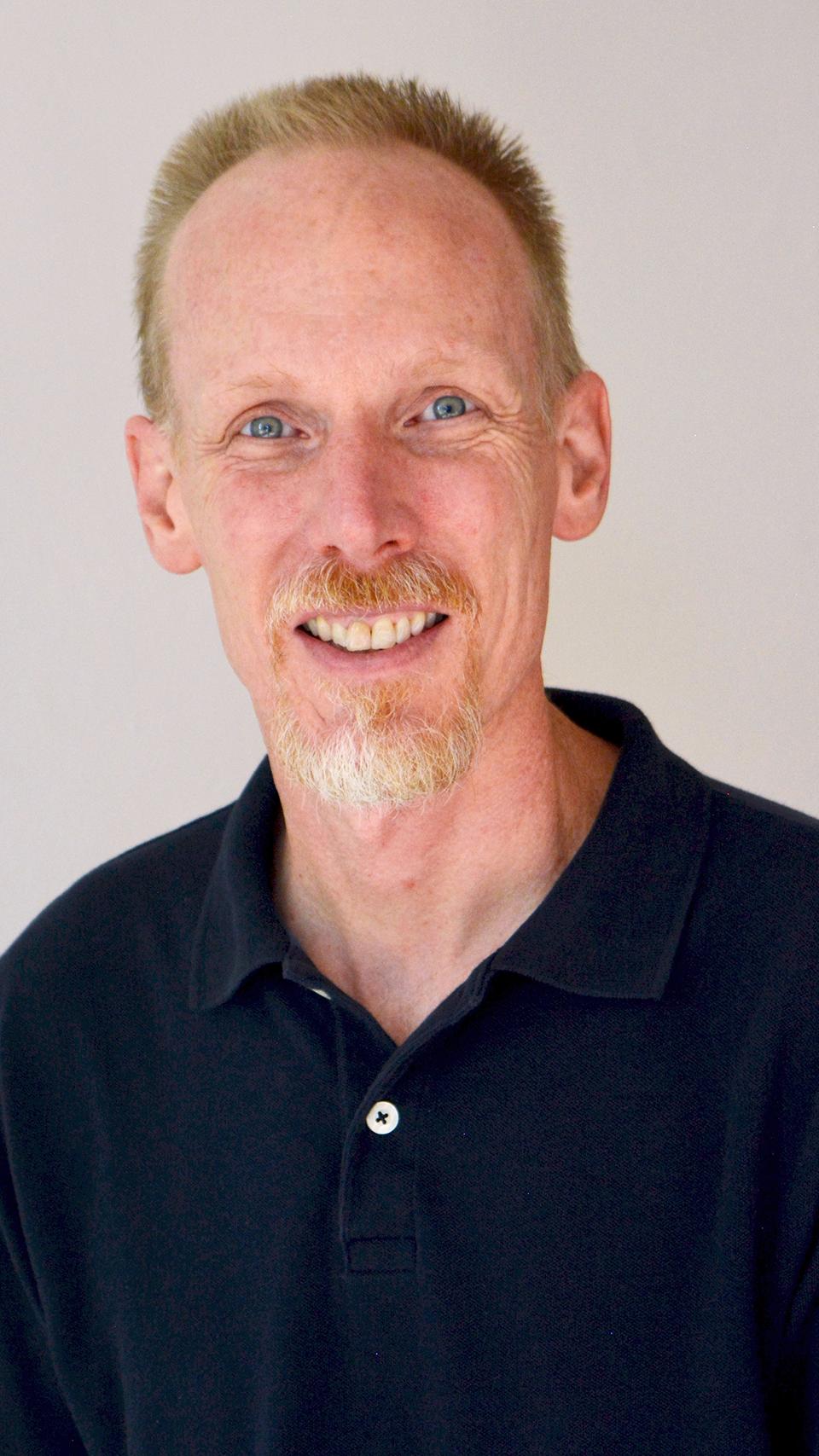 a person with a beard and mustache wearing a black shirt