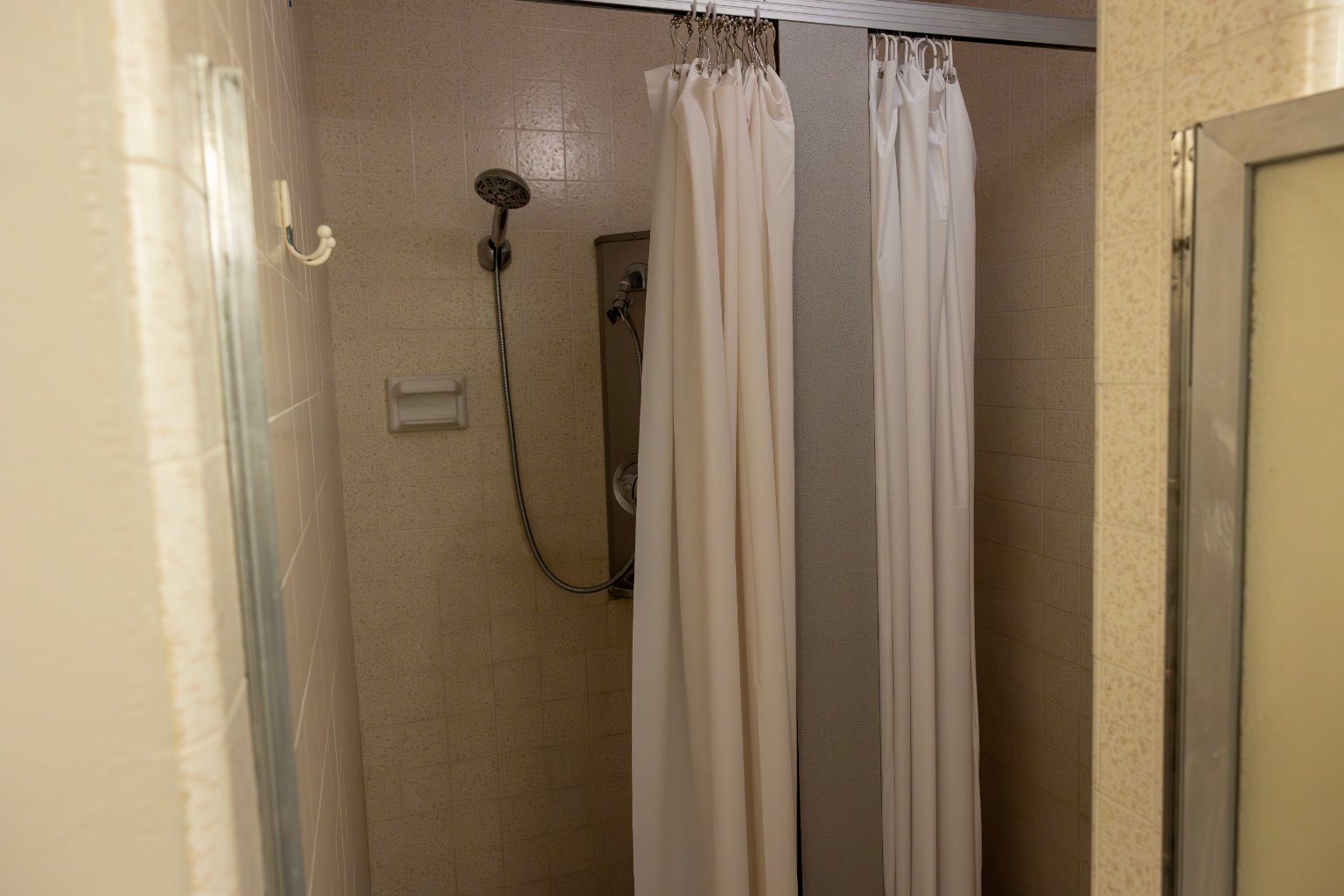 a shower with white curtains
